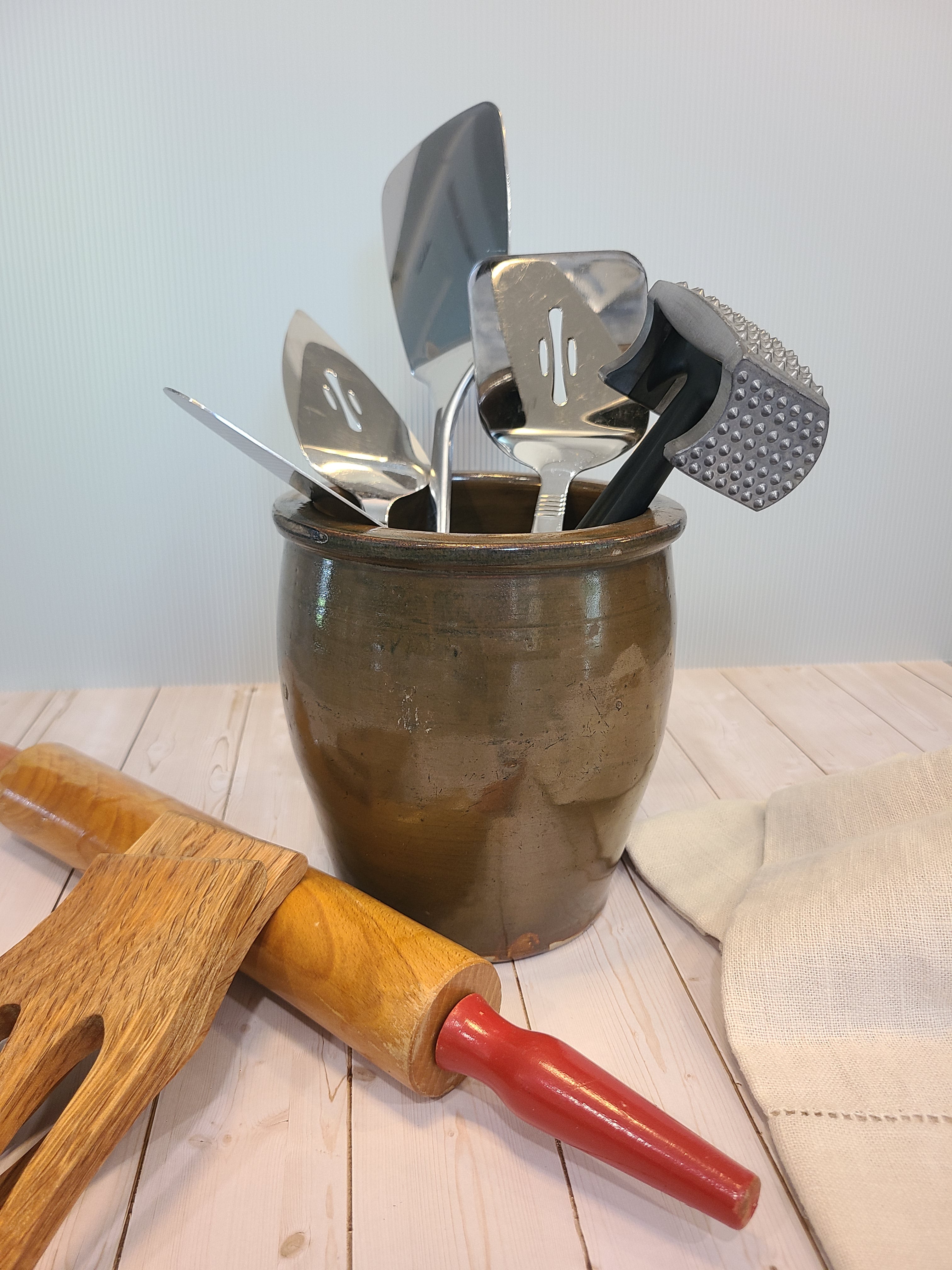 Vintage Handmade Brown Glaze Stoneware Crock holding kitchen utensils.
