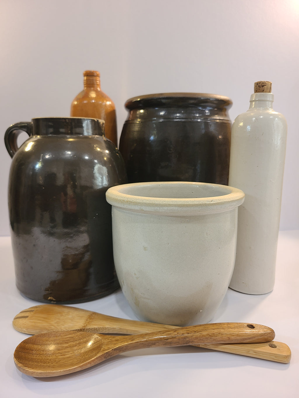 Vintage Handmade White Glazed Crock displayed with other stoneware pieces and wooden spoons.