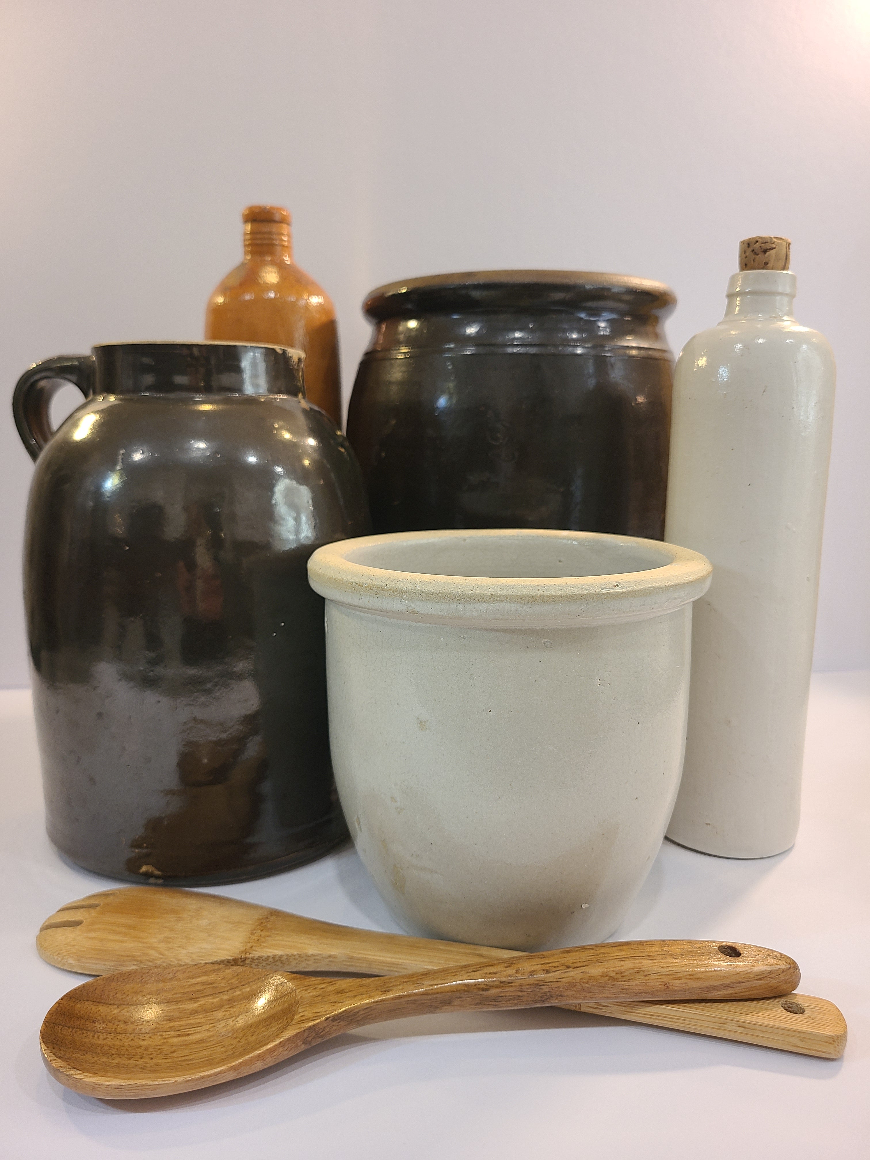 Vintage Handmade White Glazed Crock displayed with other stoneware pieces and wooden spoons.