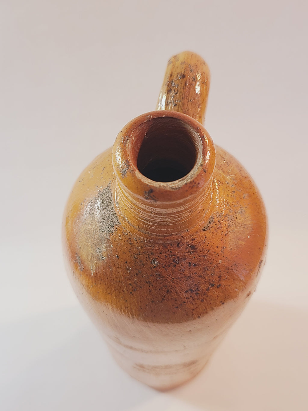 Top view of Antique 19th century terracotta colored stoneware bottle stamped with the name of Georg Kreuzberg and the Apollinaris Brunnen.