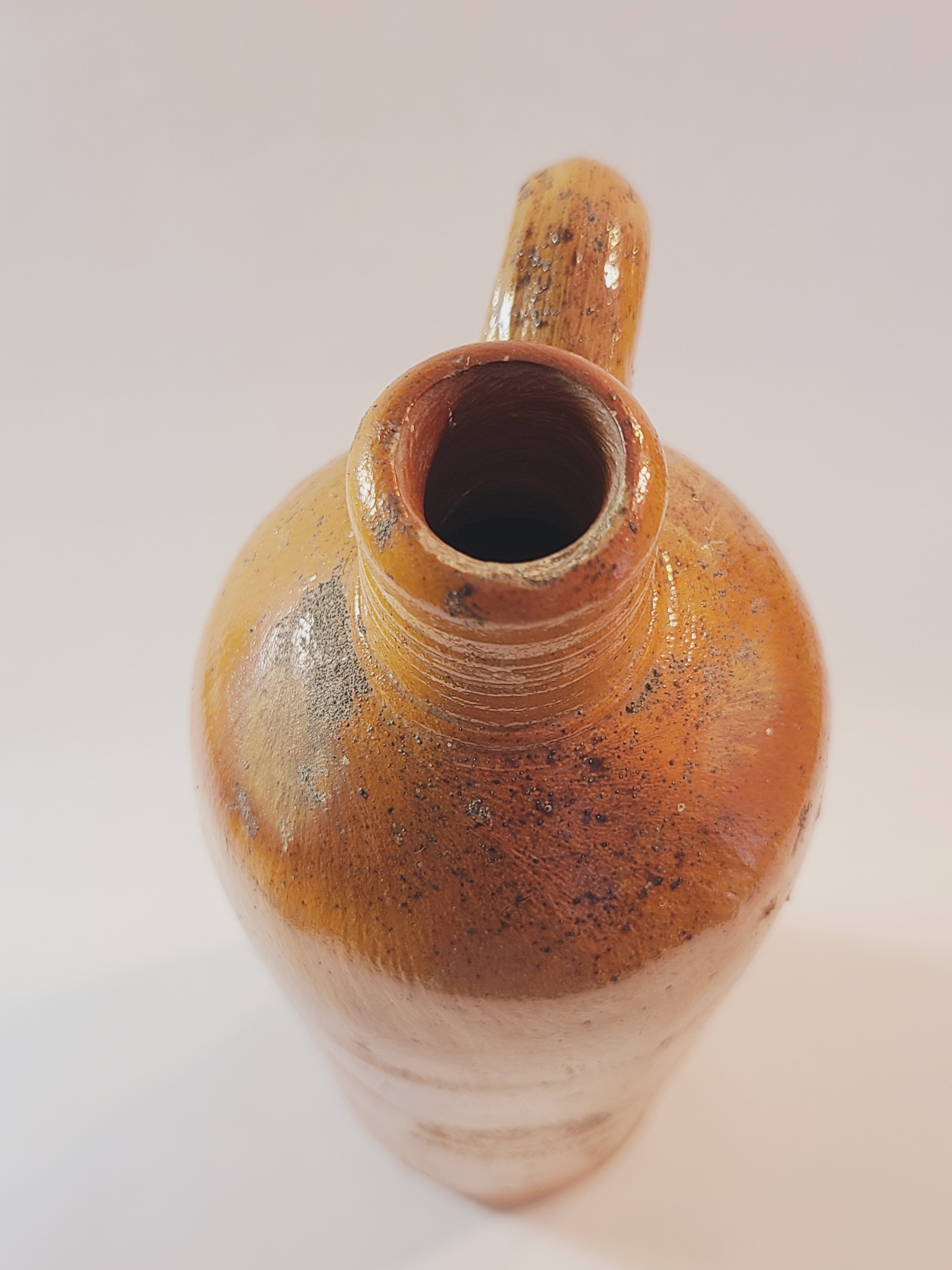 Top view of Antique 19th century terracotta colored stoneware bottle stamped with the name of Georg Kreuzberg and the Apollinaris Brunnen.