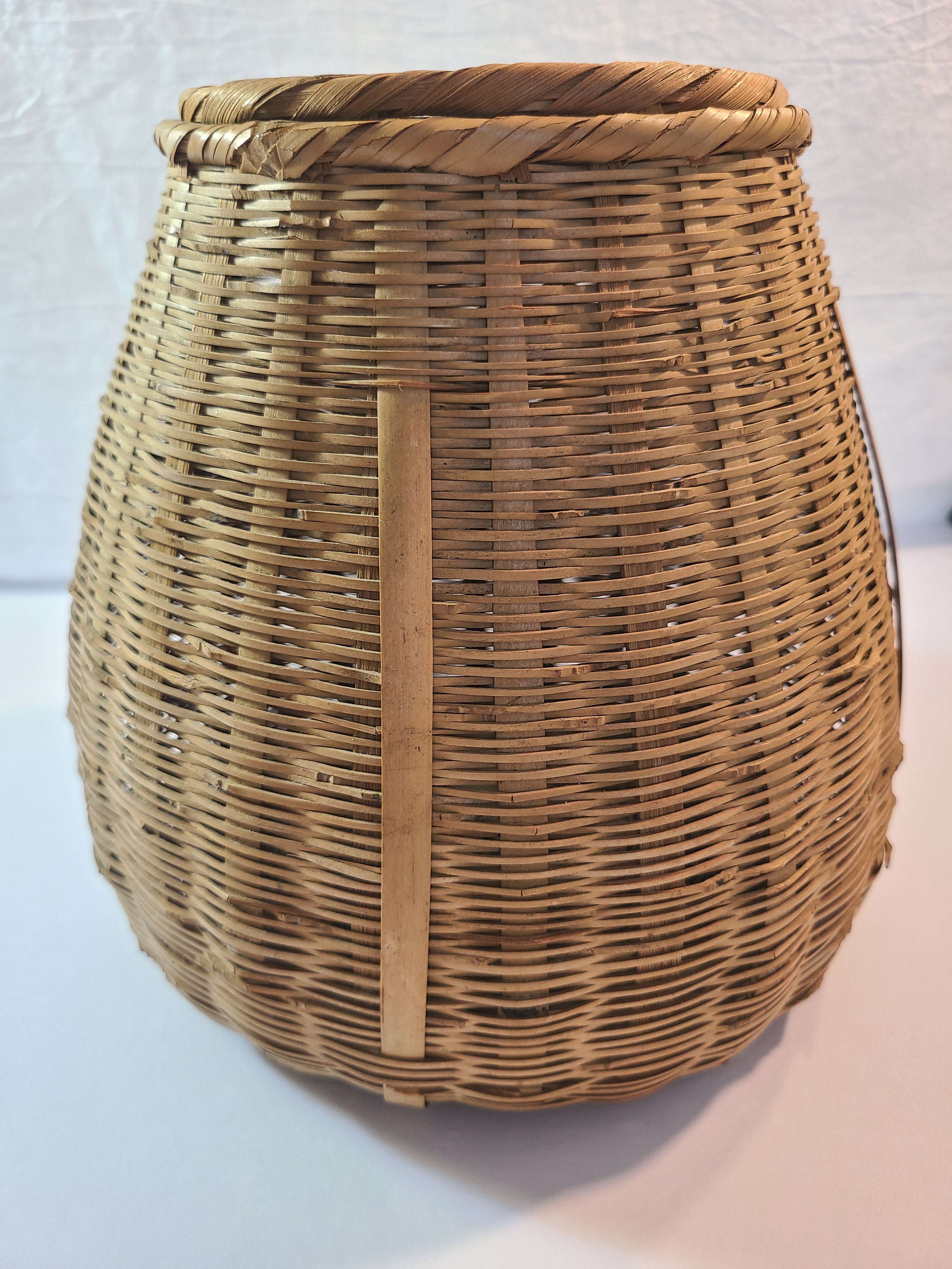 A natural woven wicker basket shown against a plain light background.