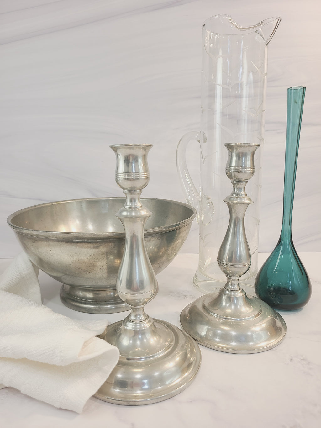 Vintage Stieff Pewter Candle holders displayed with pewter bowl, teal glass vase, clear glass pitcher.