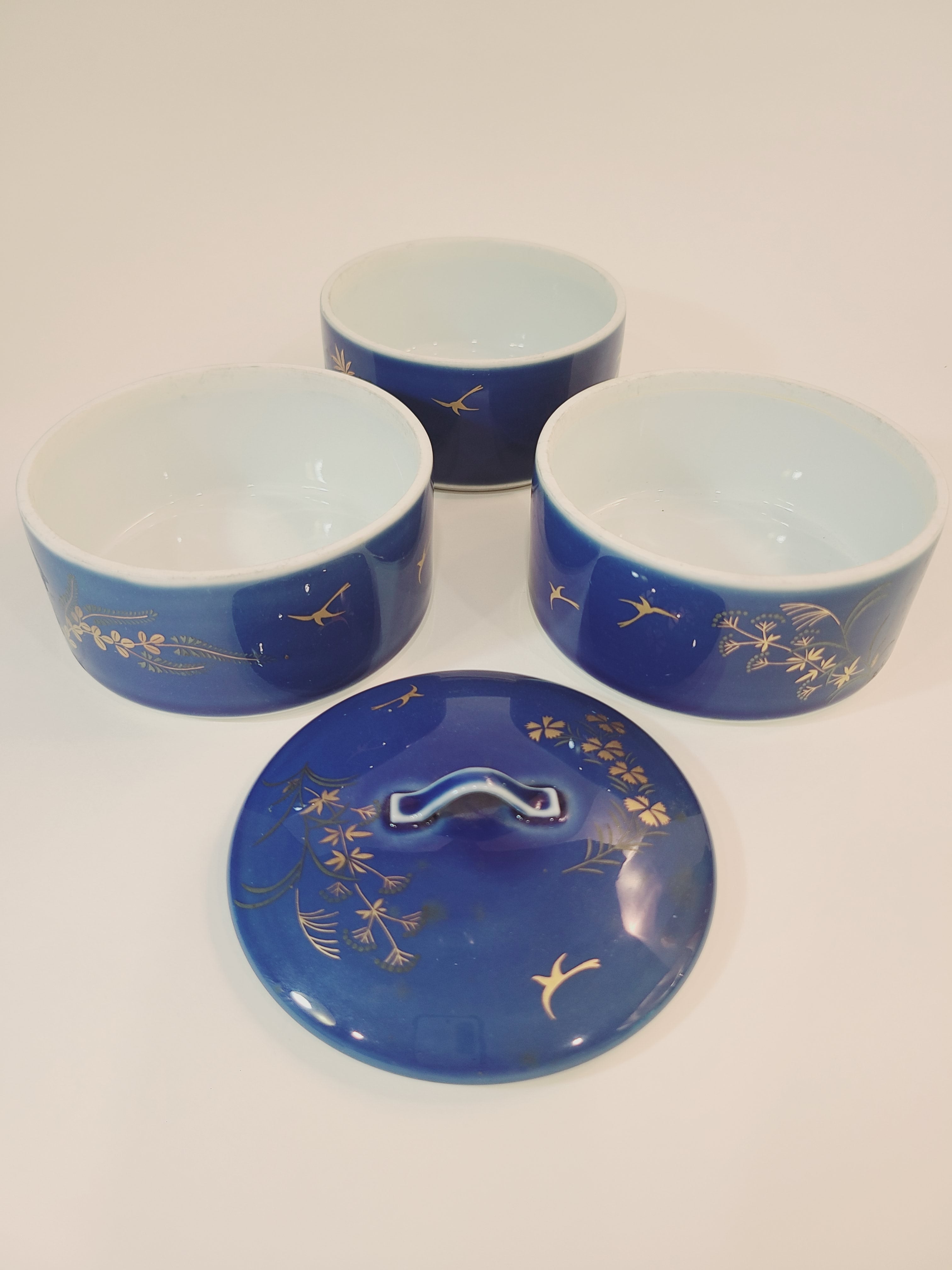 Vintage Fukagawa Seiji 3-Tier Stacking Bowl Set with Lid in lapis blue with gold accents showing bowls unstacked.
