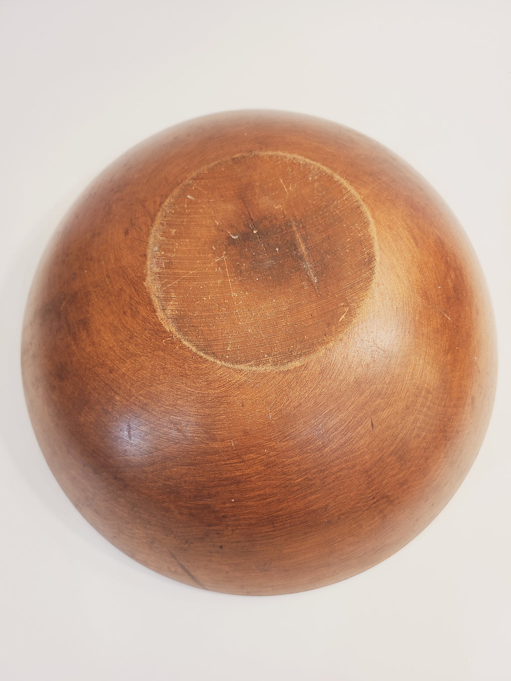 Bottom of a vintage round wooden bowl.