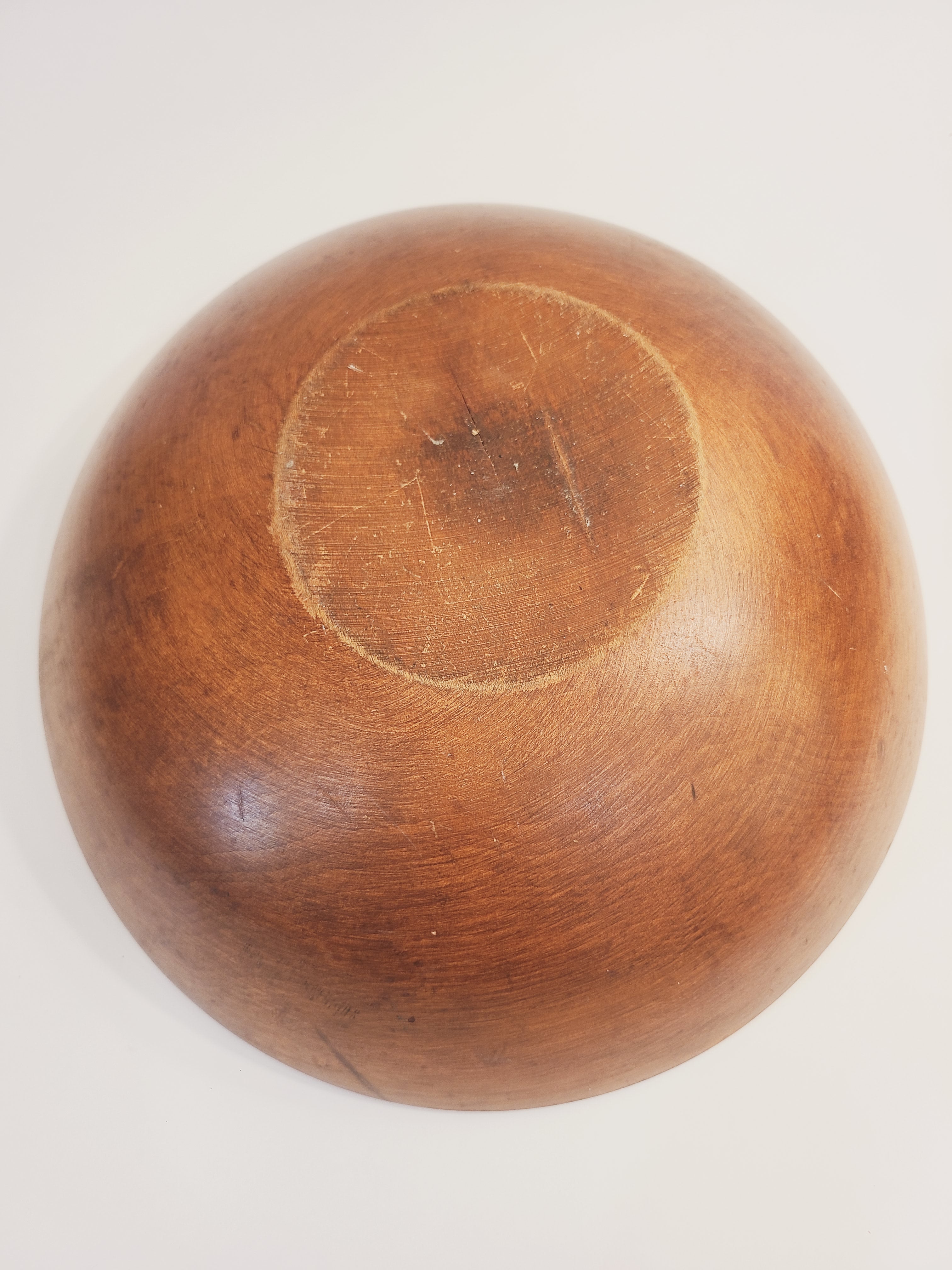 Bottom of a vintage round wooden bowl.