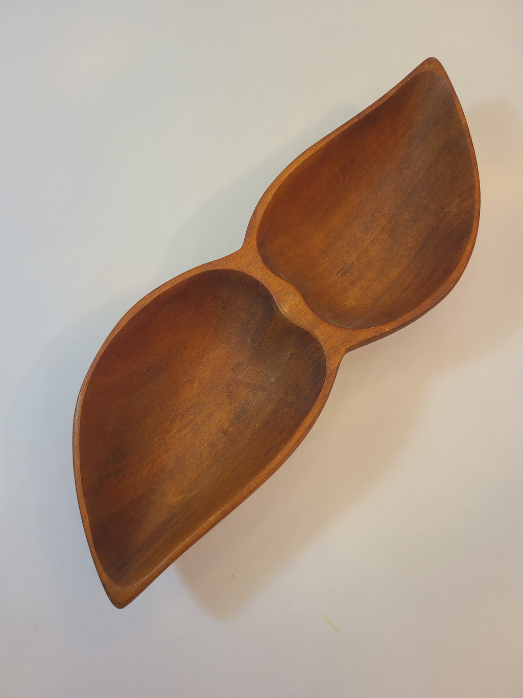 A vintage mid-century wooden serving bowl with two leaf-shaped compartments, shown on a plain off-white background.