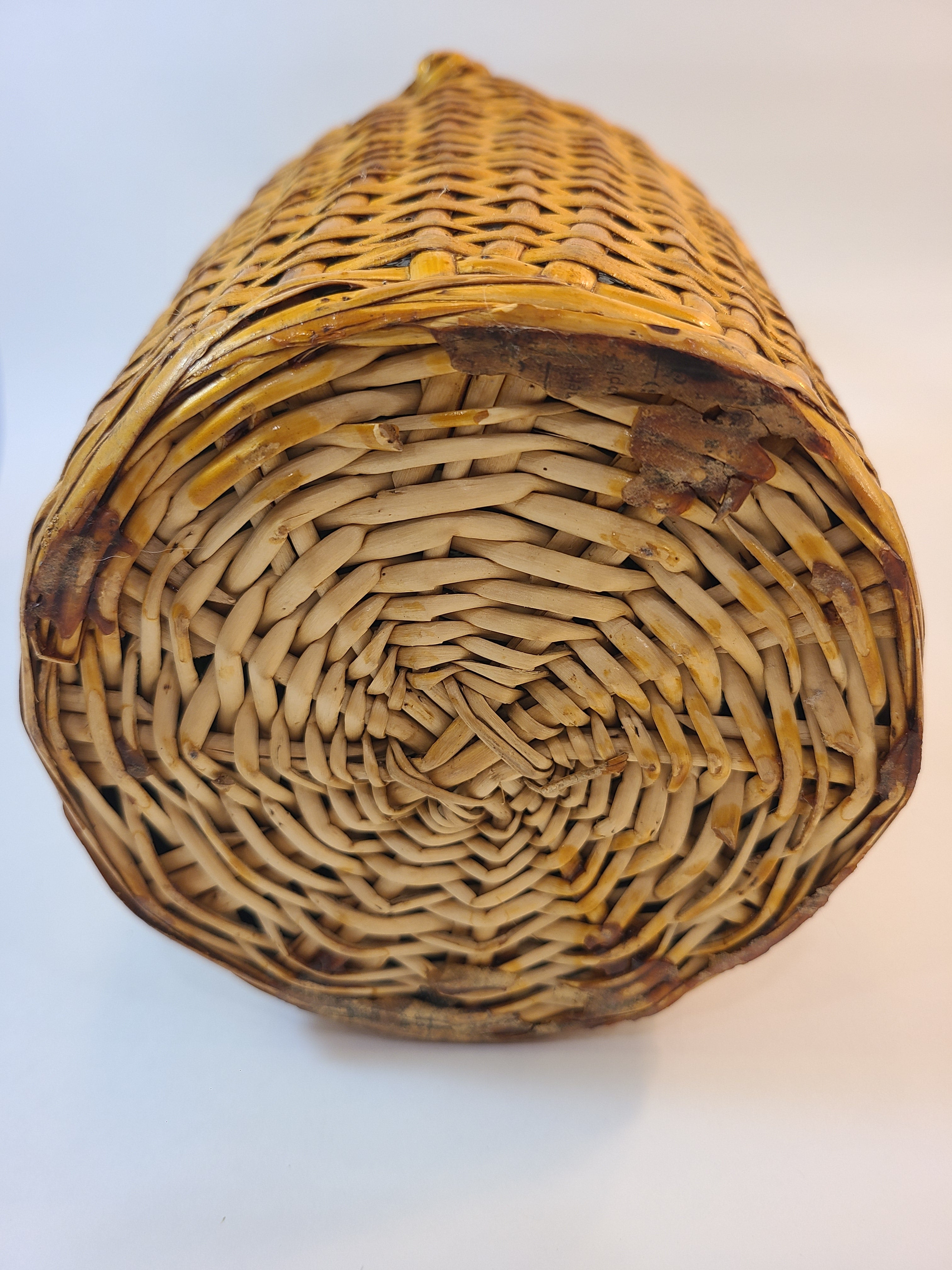 Bottom of Vintage demijohn green glass with original rattan wrapping.