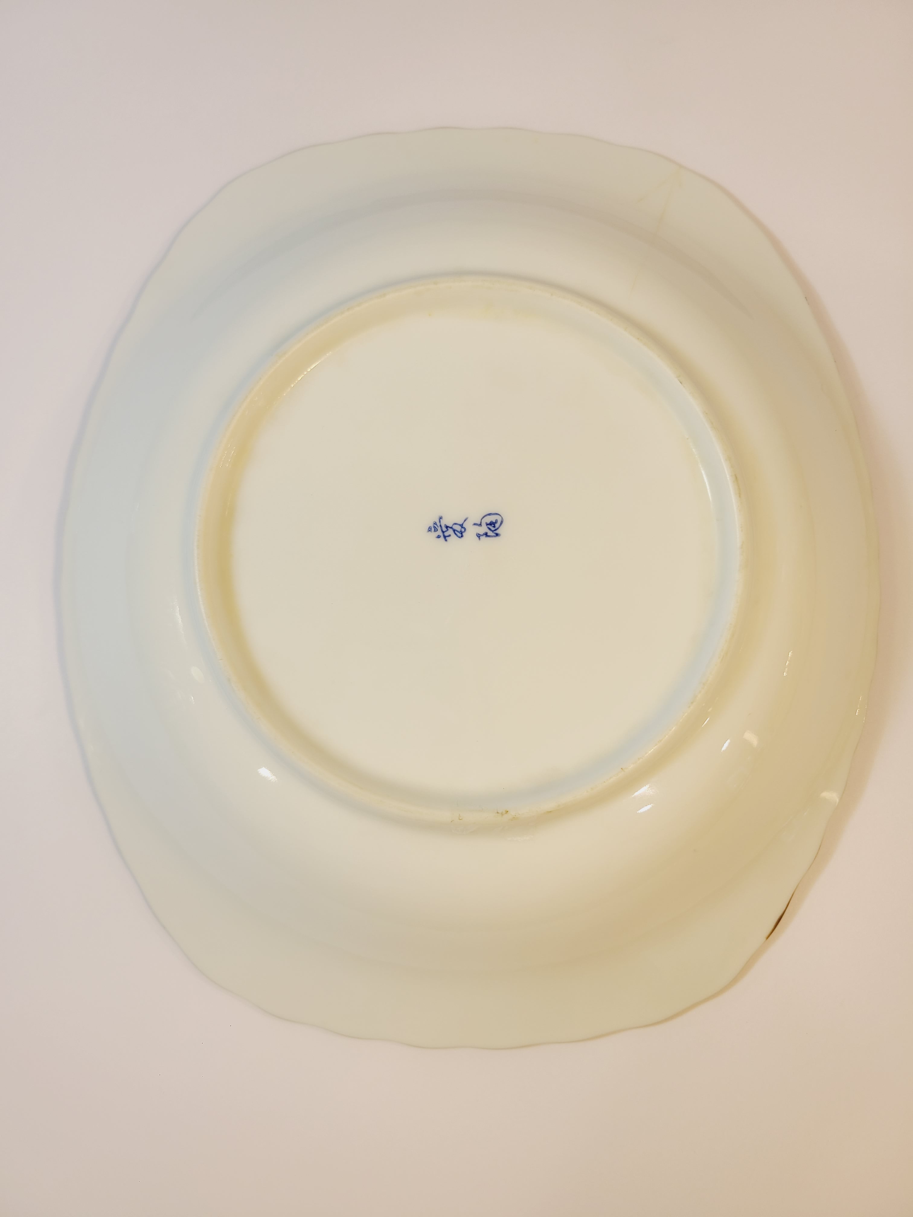 Bottom of A vintage rectangular blue and white porcelain serving platter featuring an intricate floral and vine pattern made in Japan.