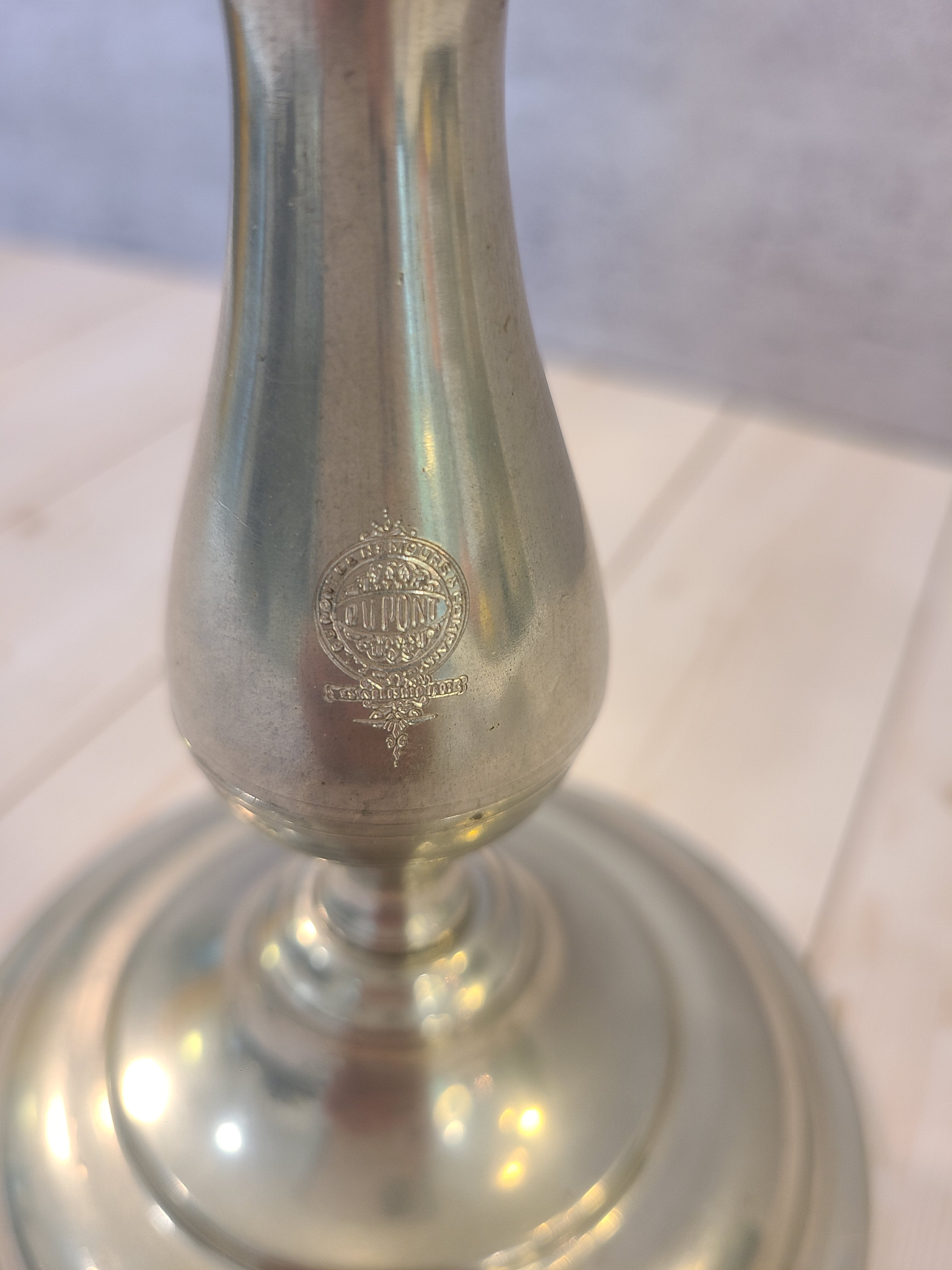 Close up of DuPont stamp on pair of vintage Stieff Pewter Candle holders.