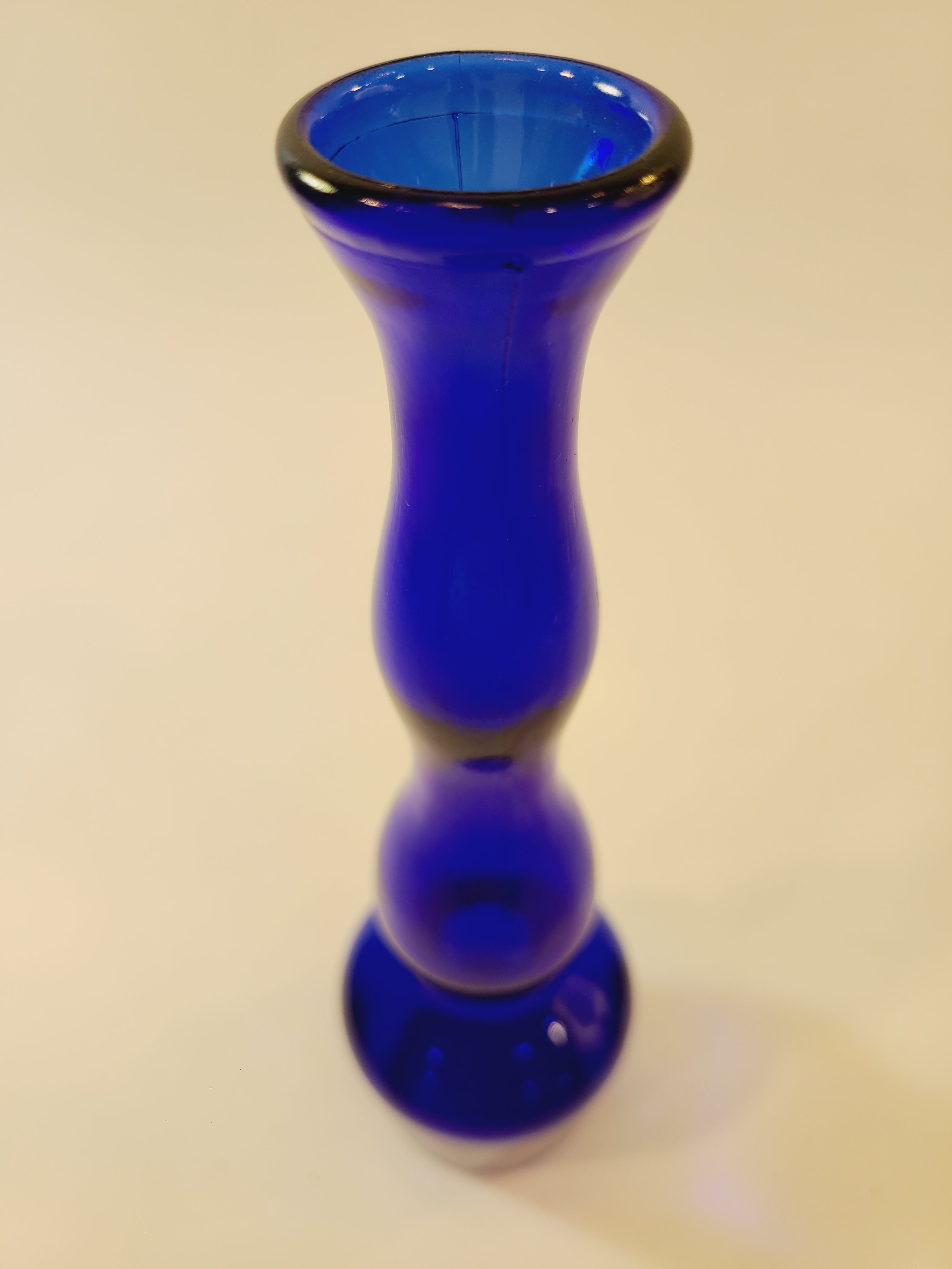 A cobalt blue glass bud vase close up.
