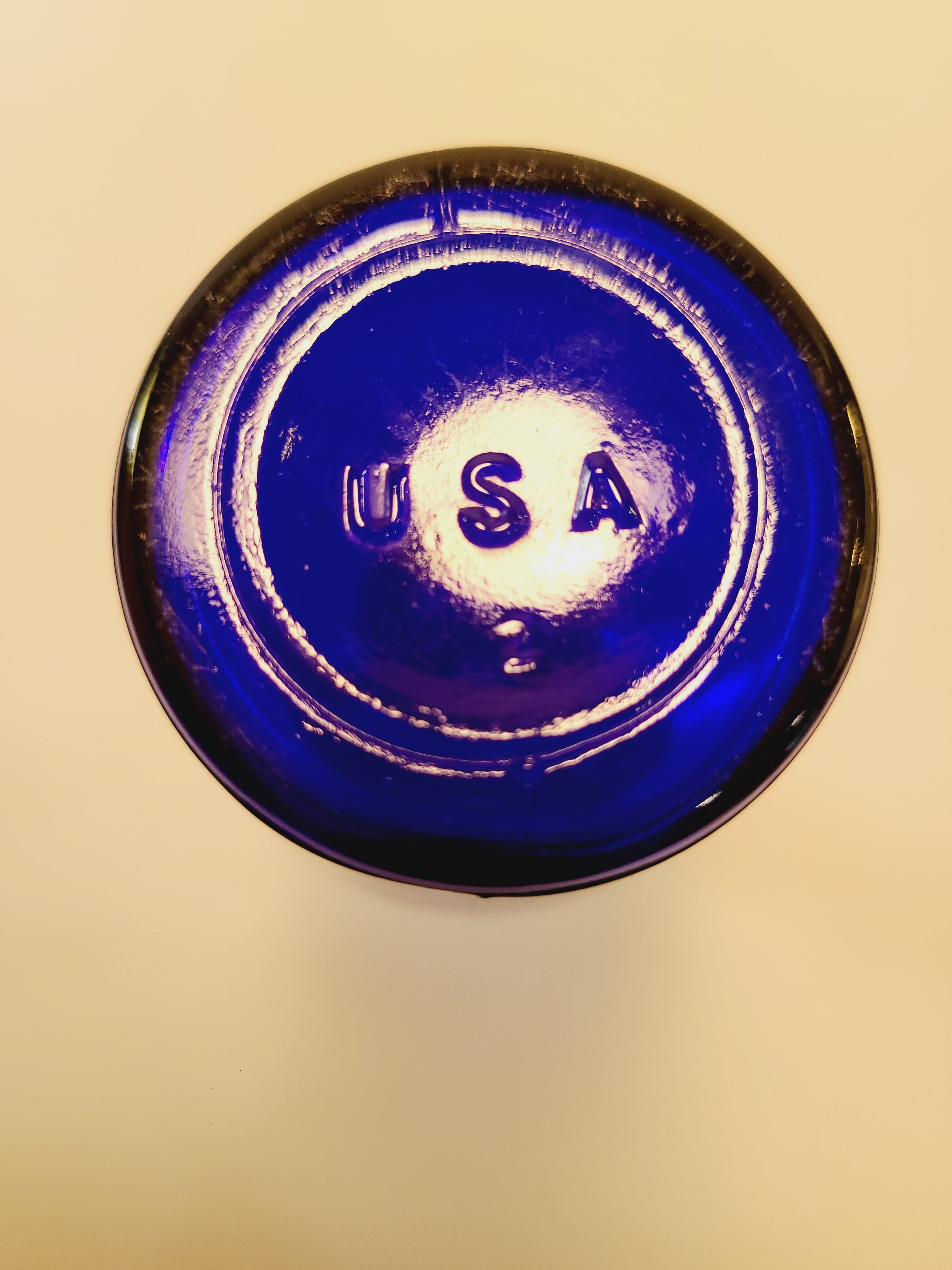 Bottom of a vintage cobalt blue glass bud vase showing the embossed USA mark.
