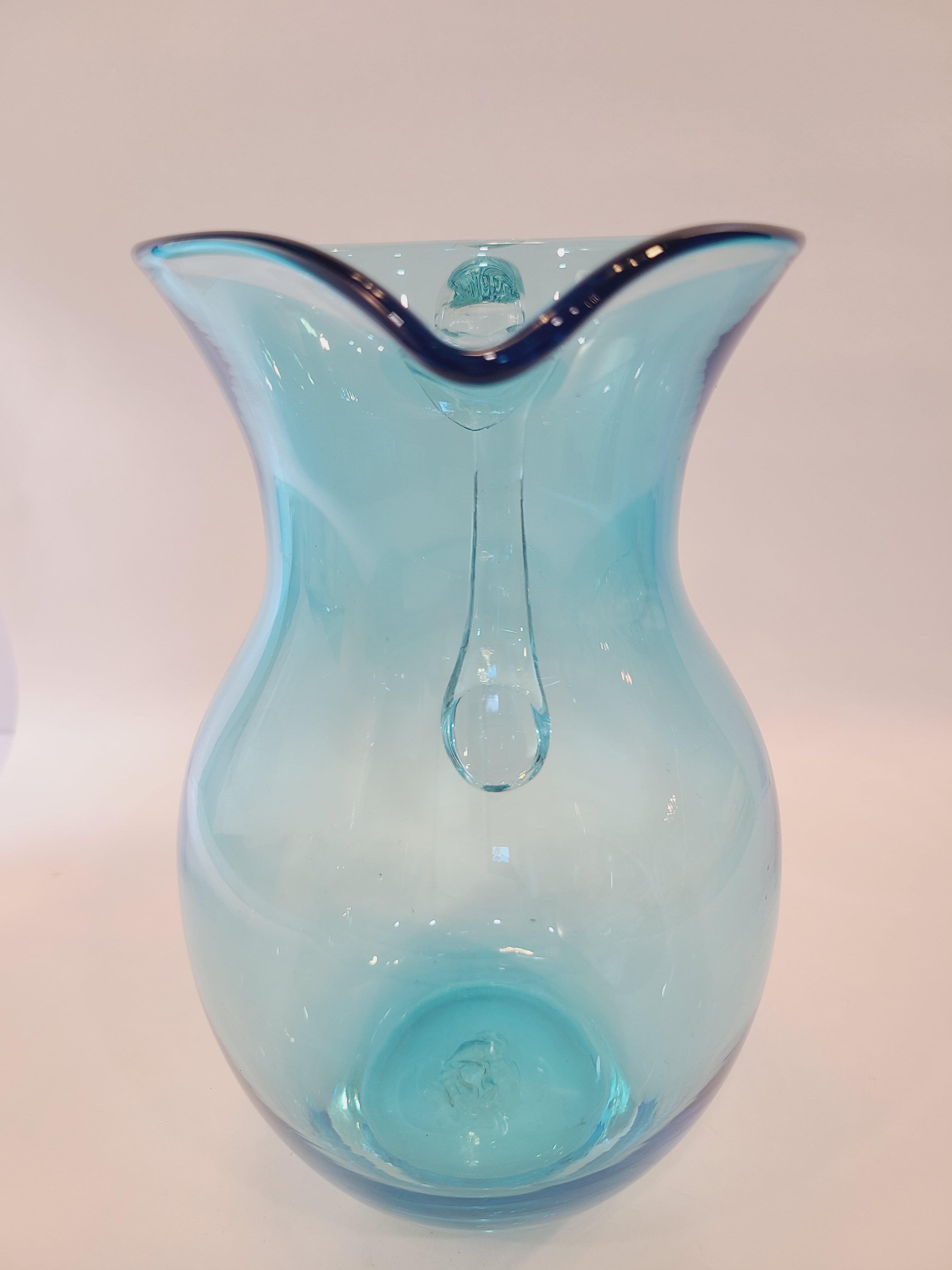 Front view of Turquoise glass vase with clear glass handle.
