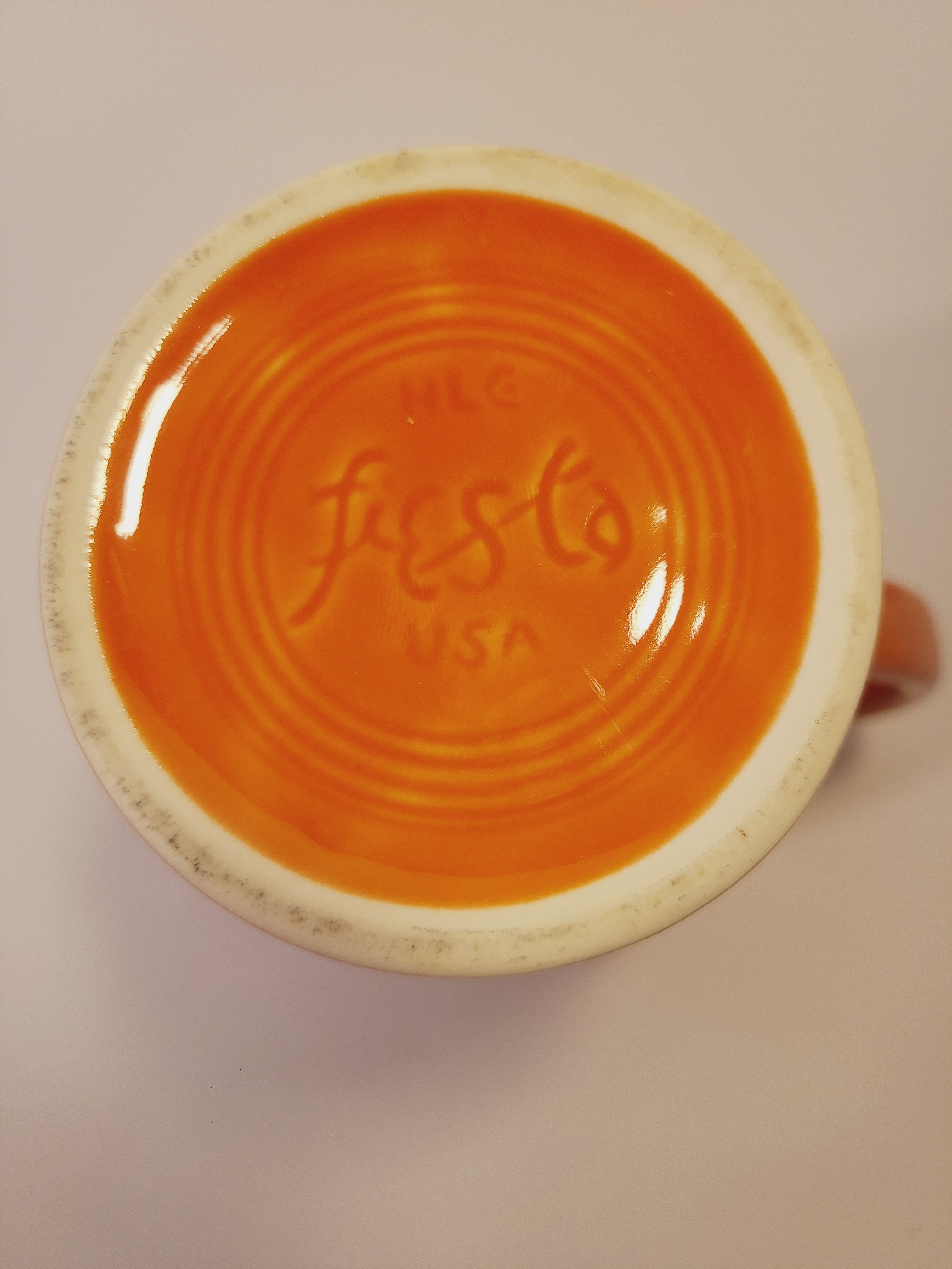 Bottom of Fiesta carafe in color Persimmon set against plain white background.