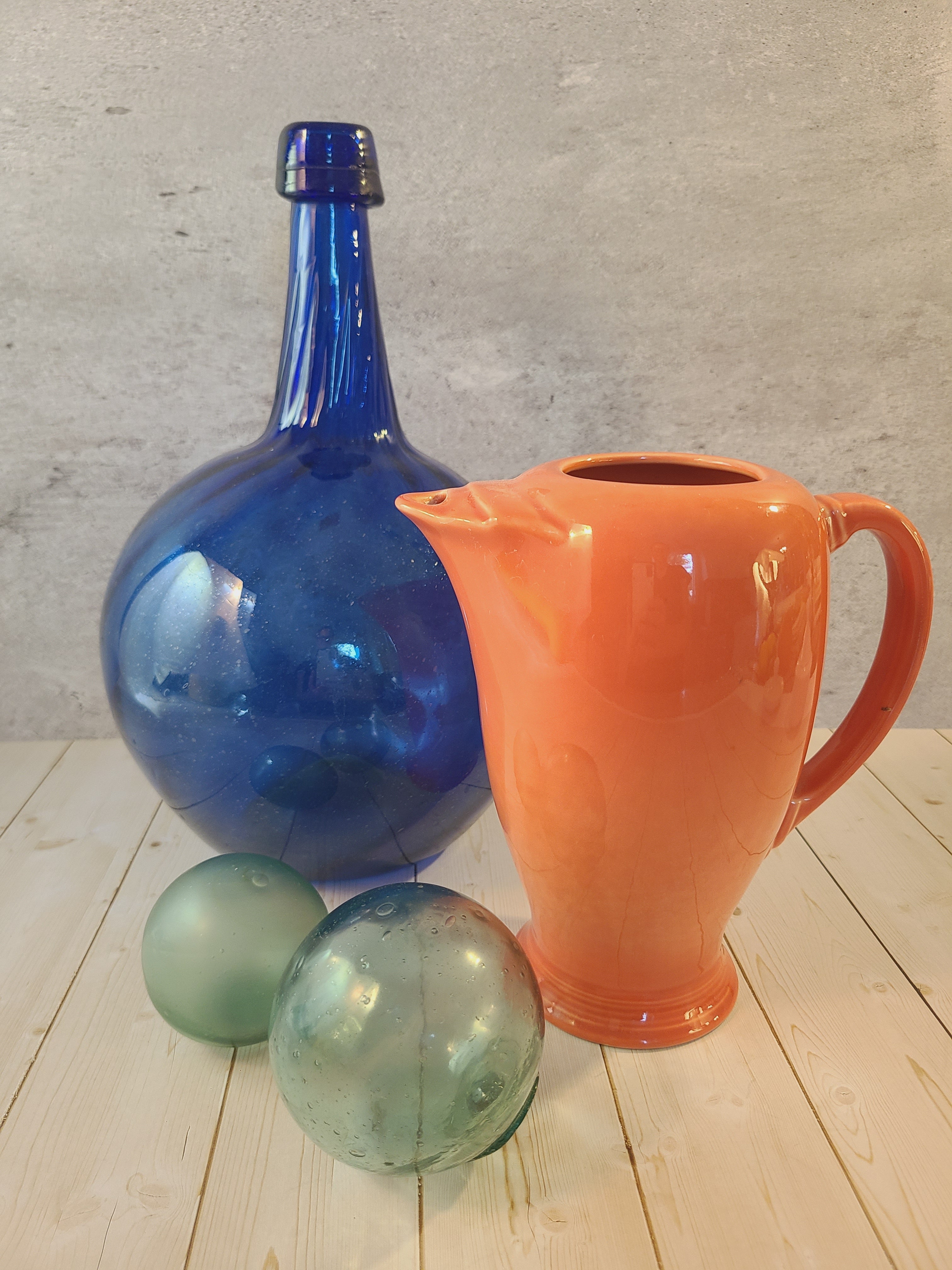Fiesta carafe in color Persimmon styled with cobalt blue bottle and fishing floats.