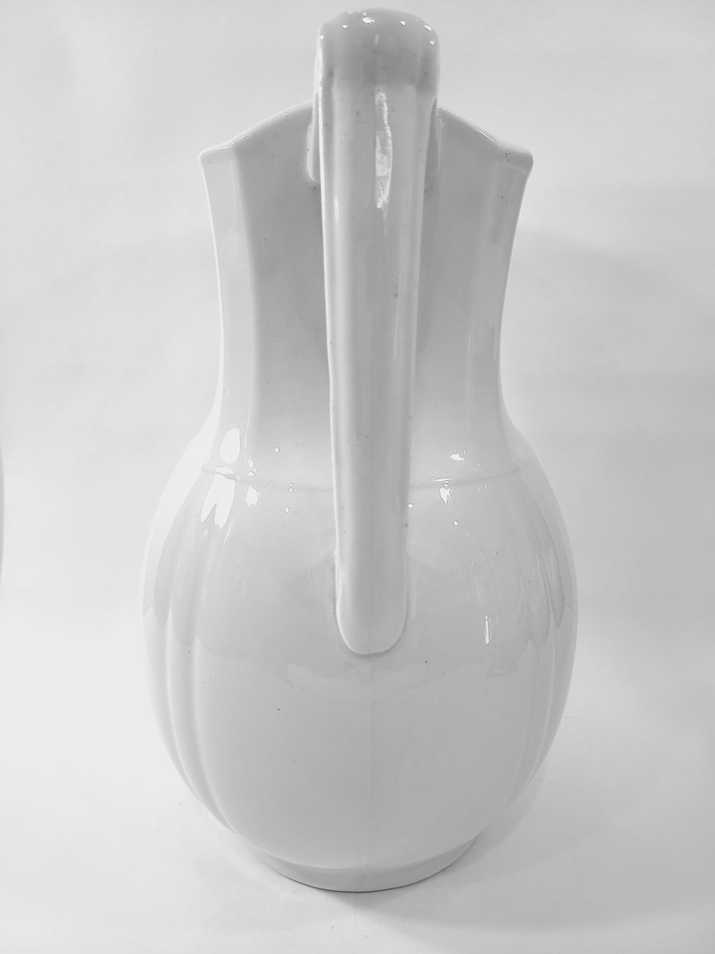 Antique white Alfred Meakin Royal Ironstone Pitcher on white background emphasizing handle.