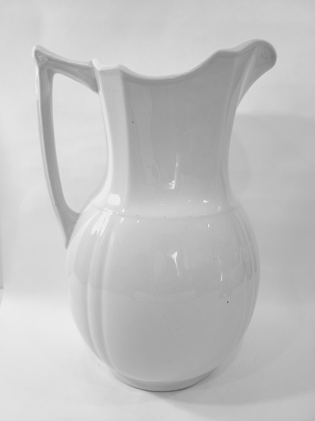 Antique white Alfred Meakin Royal Ironstone Pitcher on white background viewed from the side.