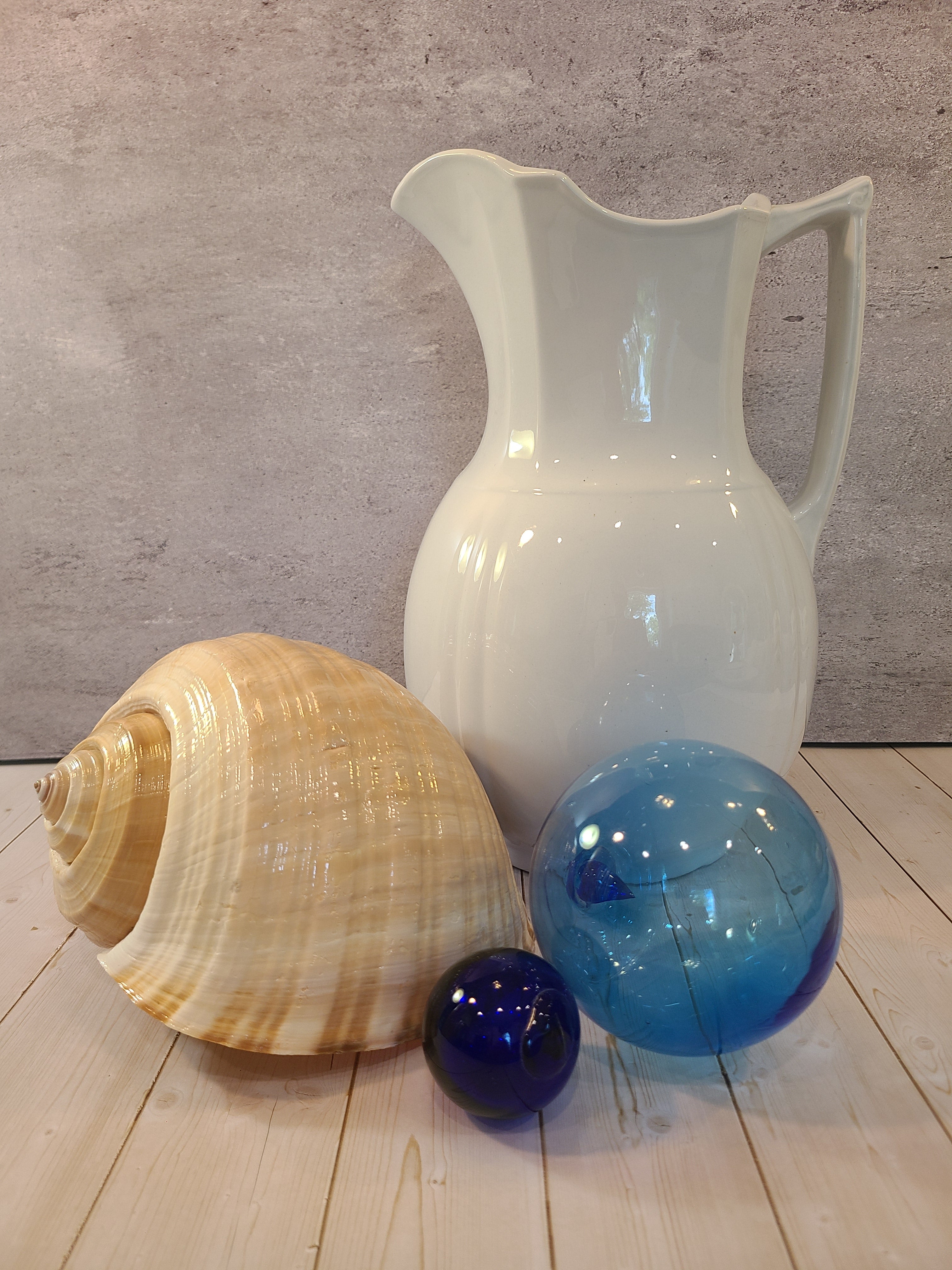 Antique white Alfred Meakin Royal Ironstone Pitcher shown with seashell and glass fishing floats.