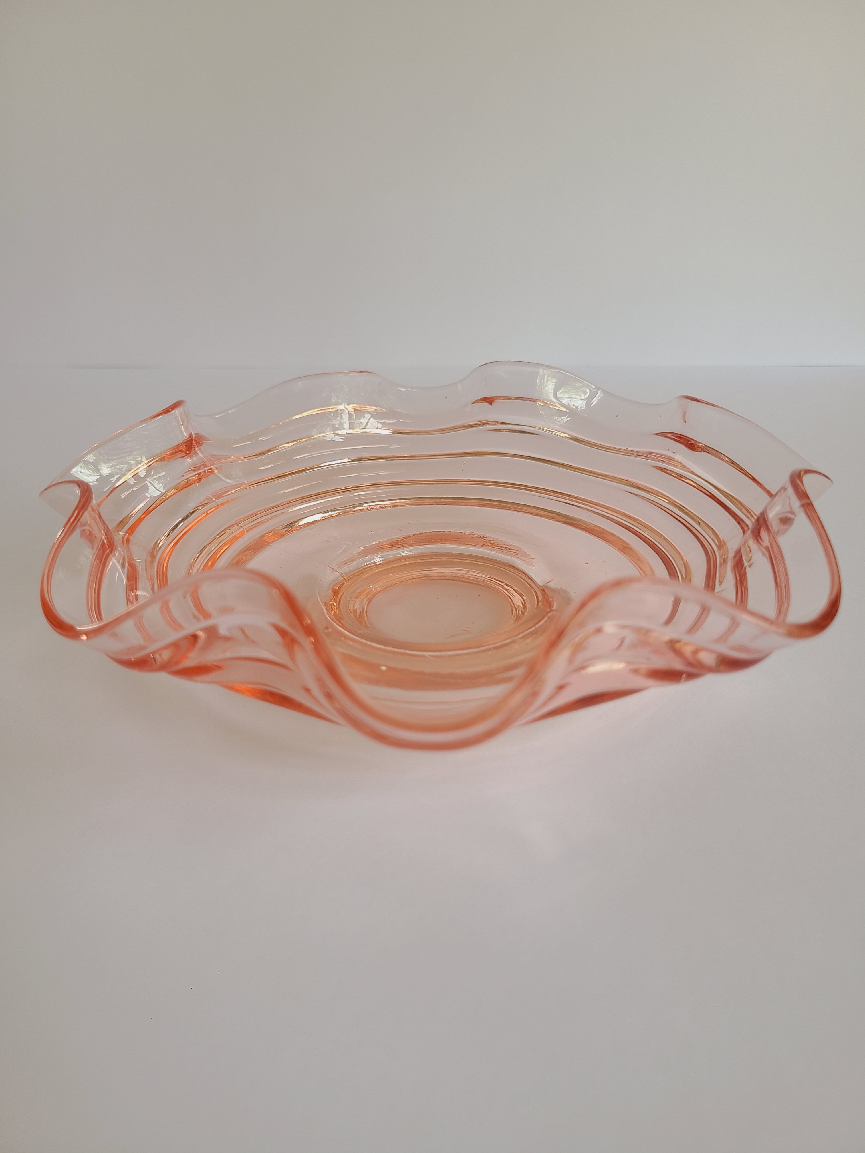 Vintage Blush colored Depression Glass Bowl with Ruffled Edge photographed from the side.