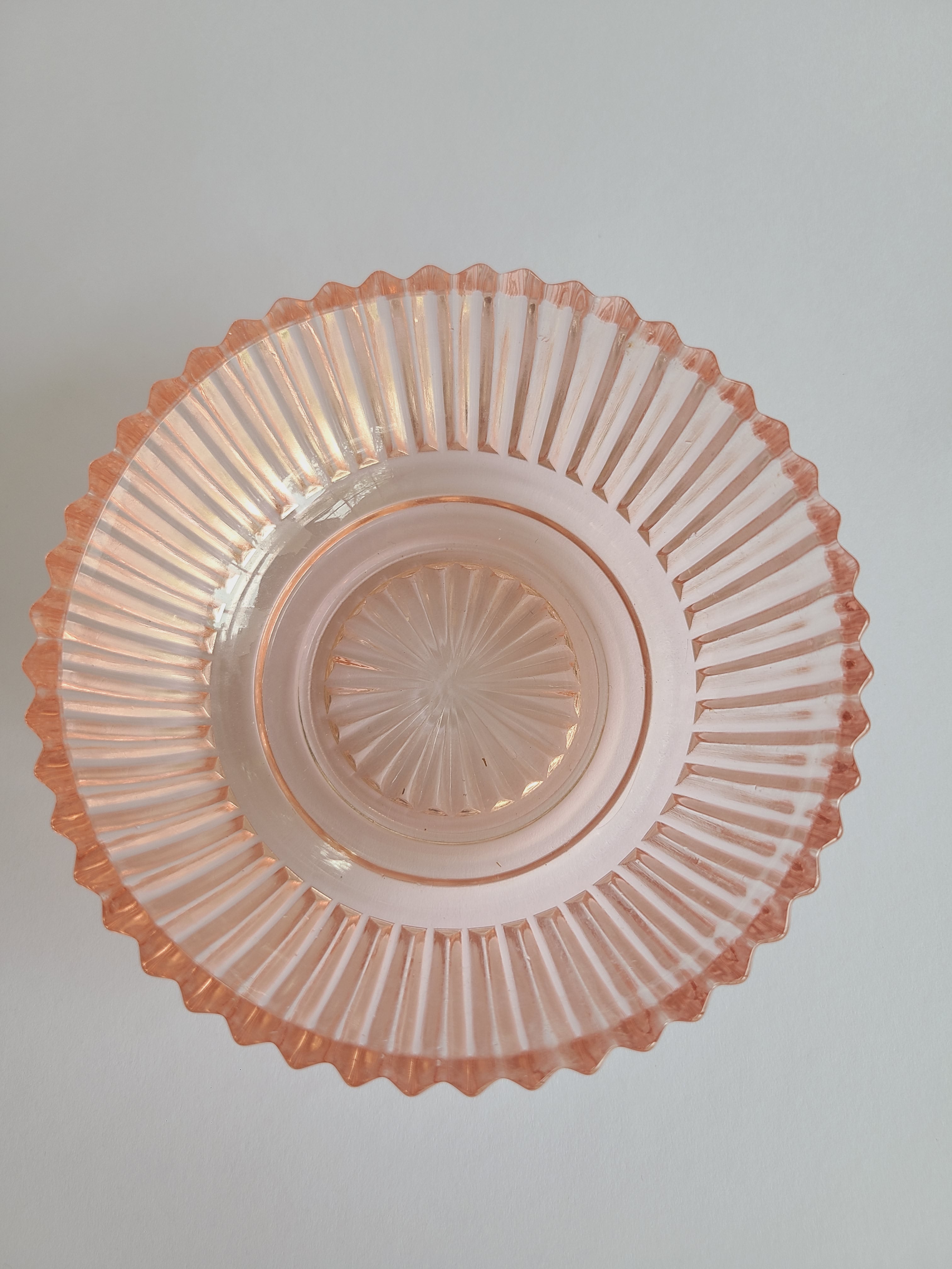 Vintage Blush colored Depression Glass Bowl with Ridged Detailing photographed from above.