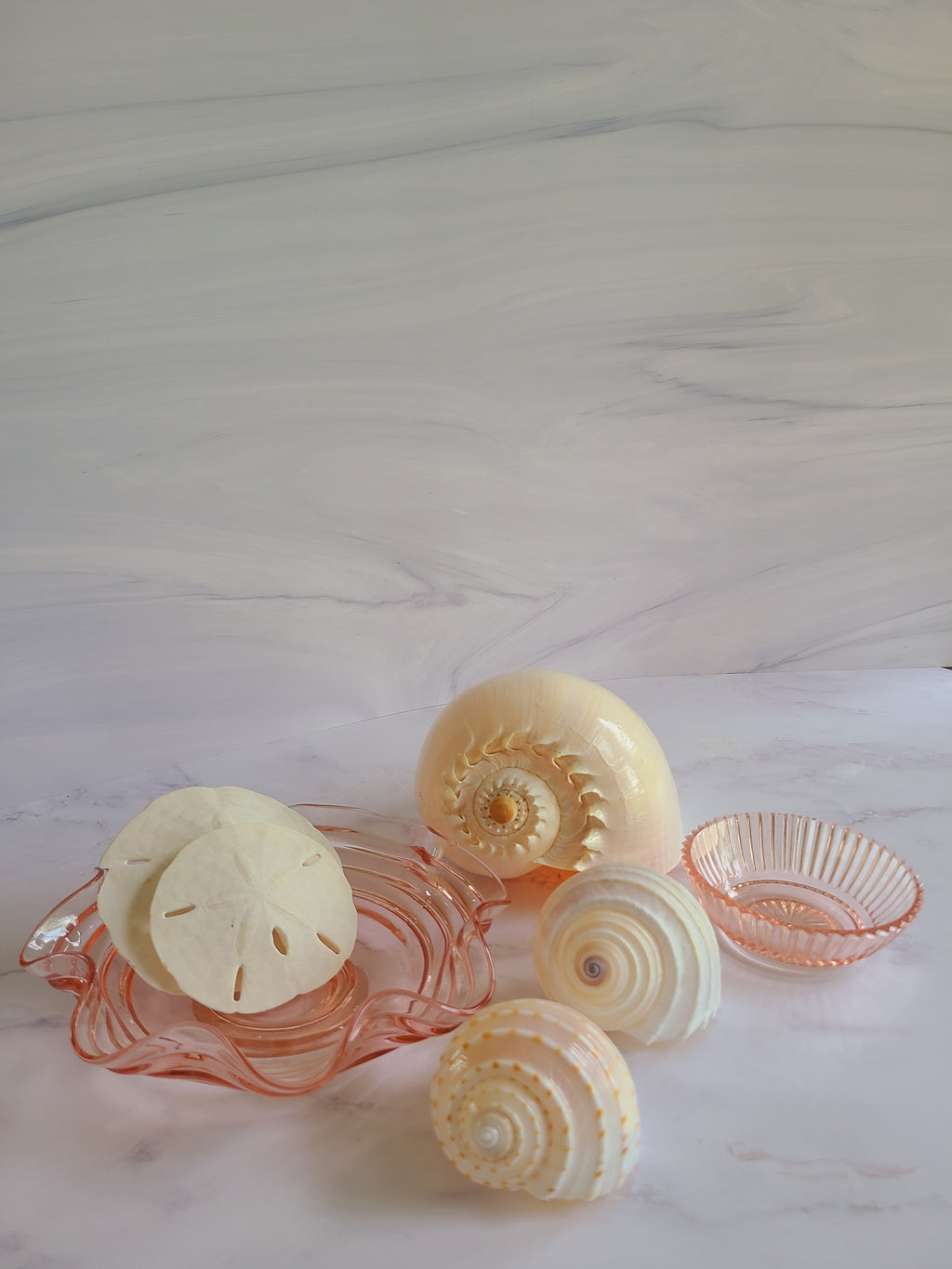 Vintage Blush colored Depression Glass Bowl with Ridged Detailing displayed with seashells.