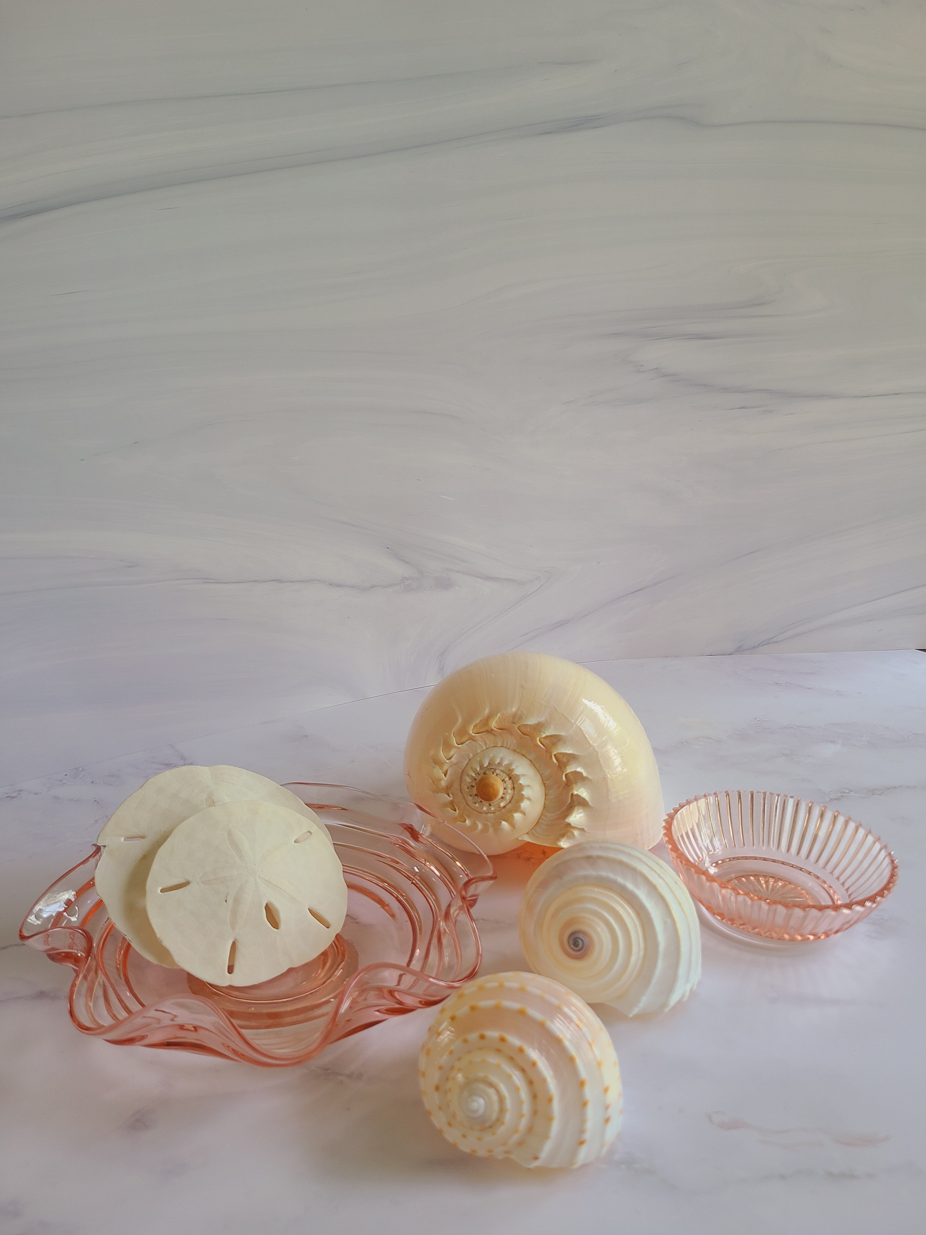 Vintage Blush colored Depression Glass Bowl with Ridged Detailing displayed with seashells.