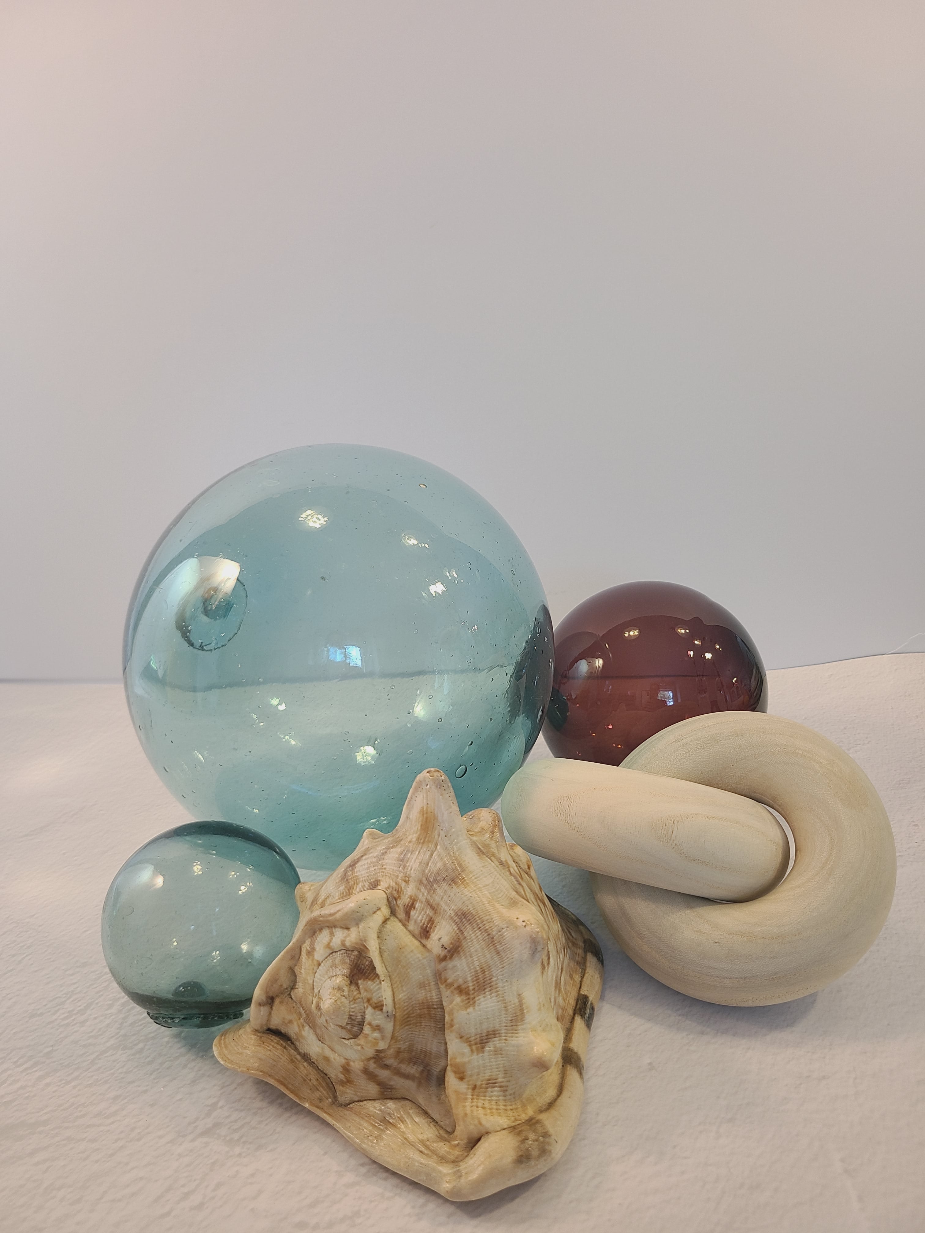Authentic Glass Fishing Float 7" diameter in classic blue-green shown with smaller glass fishing floats and seashell.