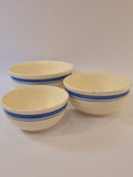 Three vintage cream-colored ceramic bowls with blue stripes made in East Germany DDR.