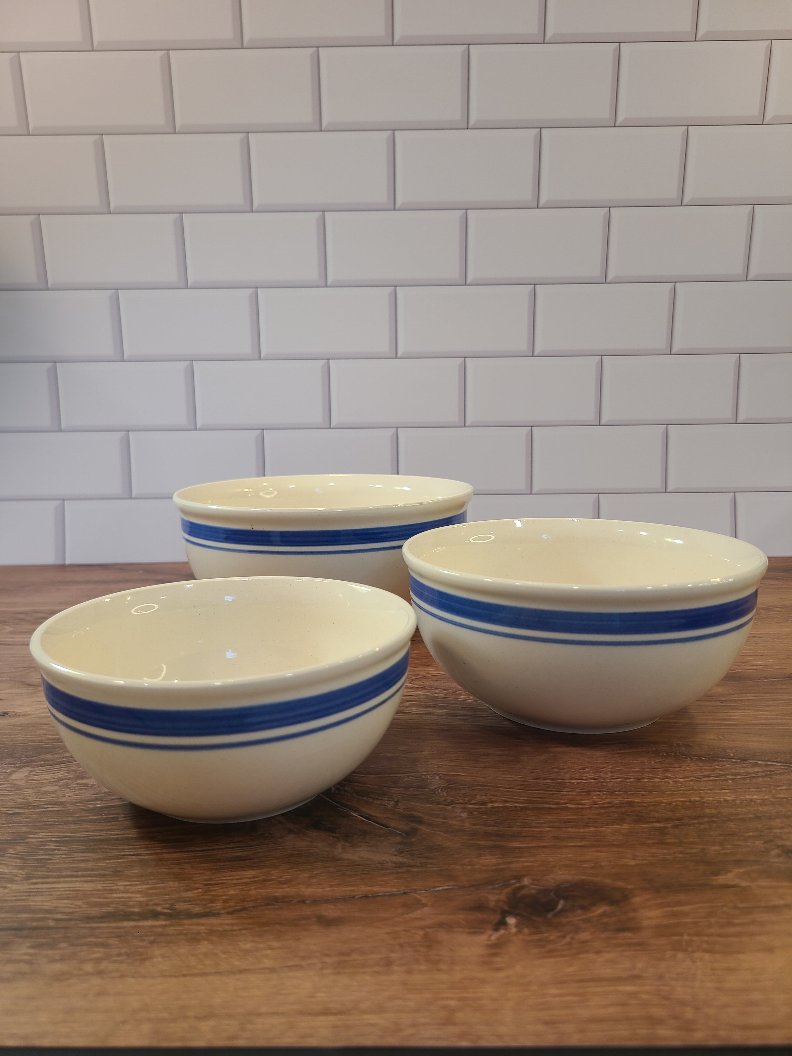Vintage cream-colored nesting ceramic bowls with blue bands made in East Germany DDR.