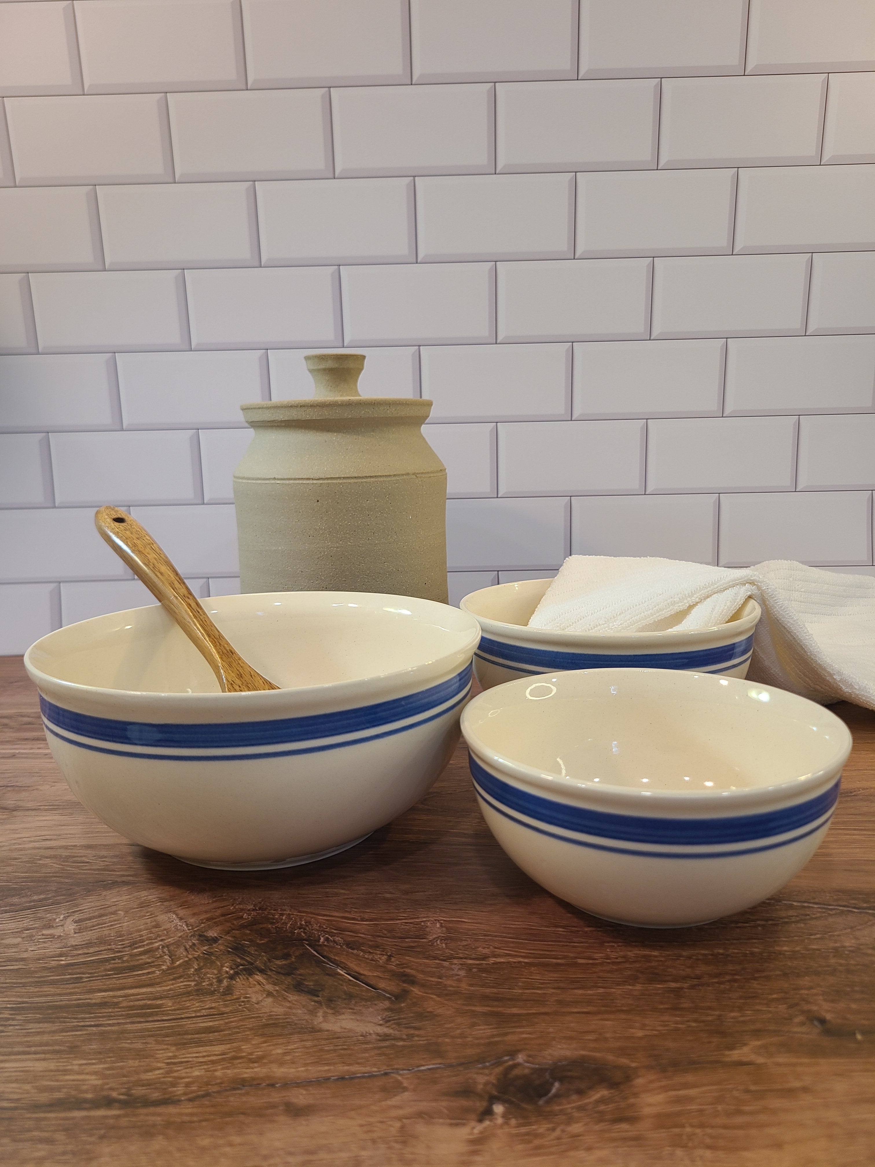 A set of vintage cream-colored ceramic bowls with blue bands made in East Germany DDR.