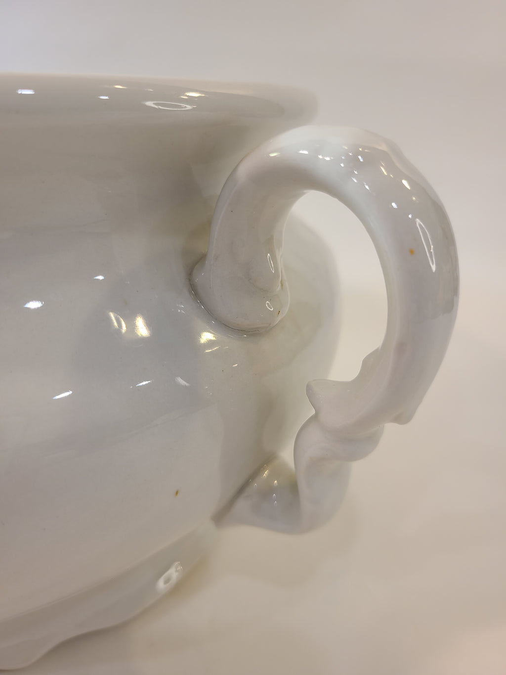 Close up of handle of white Antique Mellor, Taylor & Co. English Ironstone Chamber Pot.