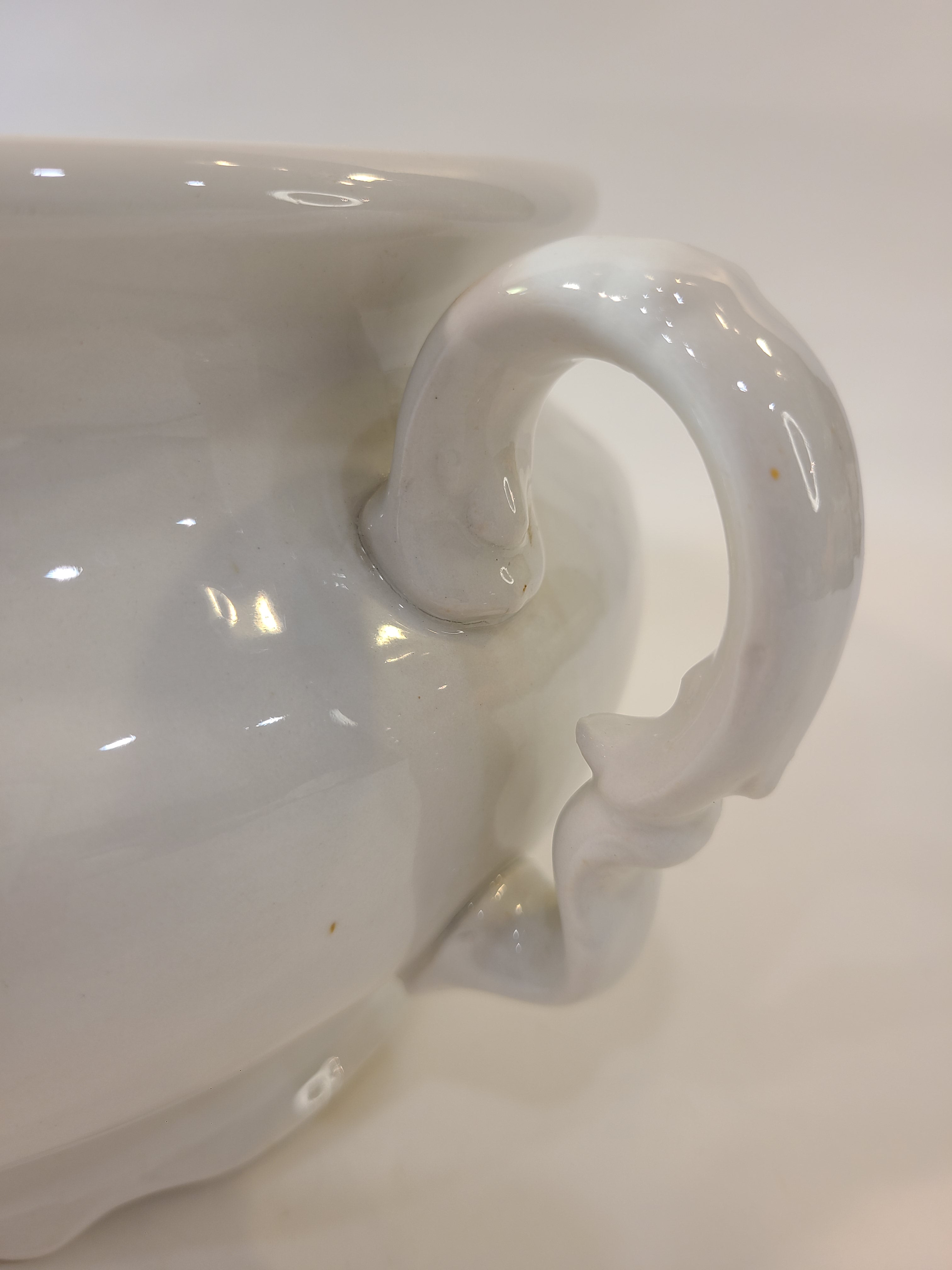 Close up of handle of white Antique Mellor, Taylor & Co. English Ironstone Chamber Pot.