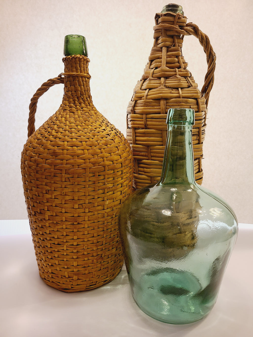 Vintage Green Glass Demijohn 10" shown with two other demijohns with wicker casing