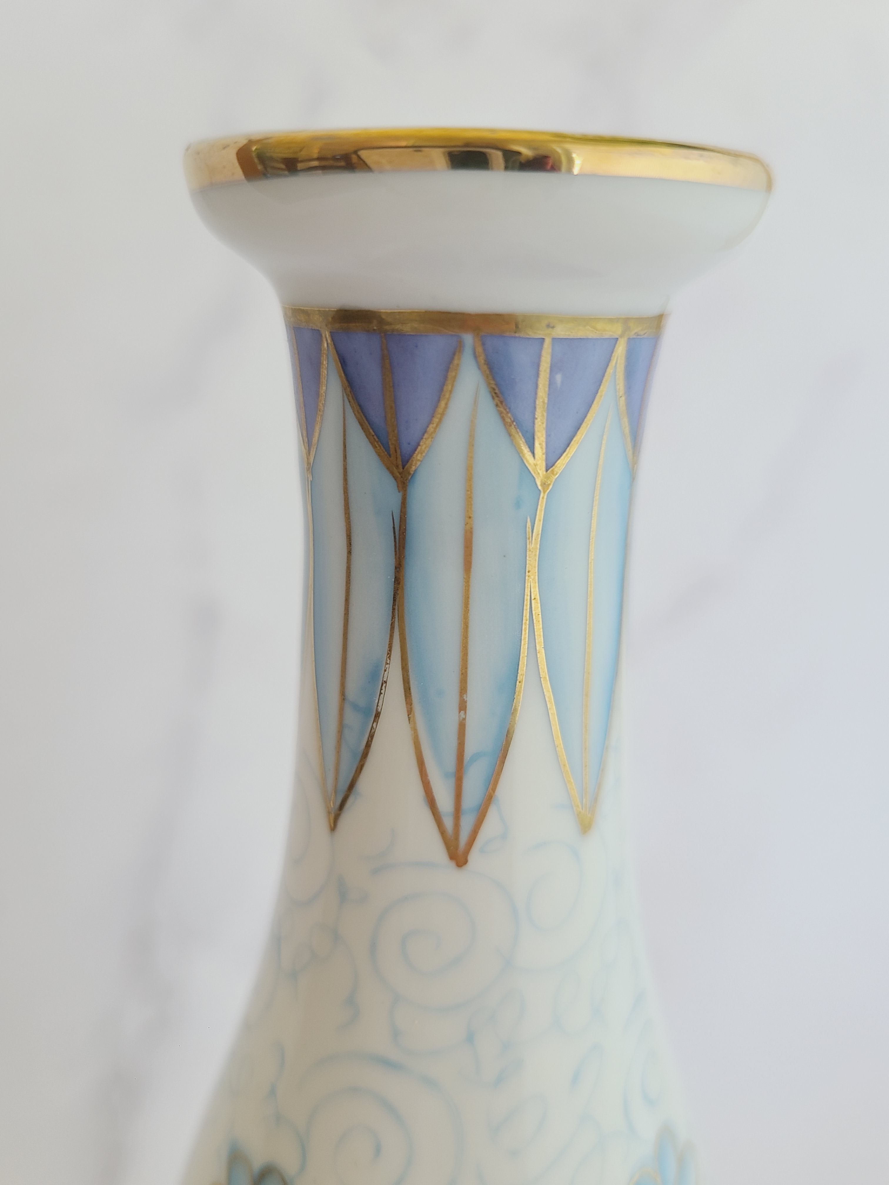 Close up of neck of Andrea by Sadek vintage white porcelain vase made in Japan hand-painted with light blue floral motifs, gold accents, and a blue-and-gold patterned band at the neck. 
