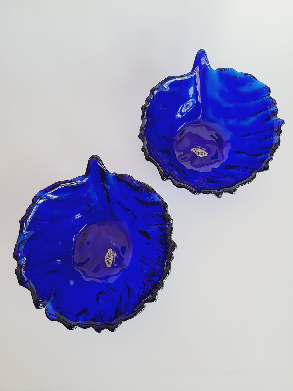 Two vintage Blenko Cabbage Pattern Bowls in Cobalt Blue on white background shown from above.