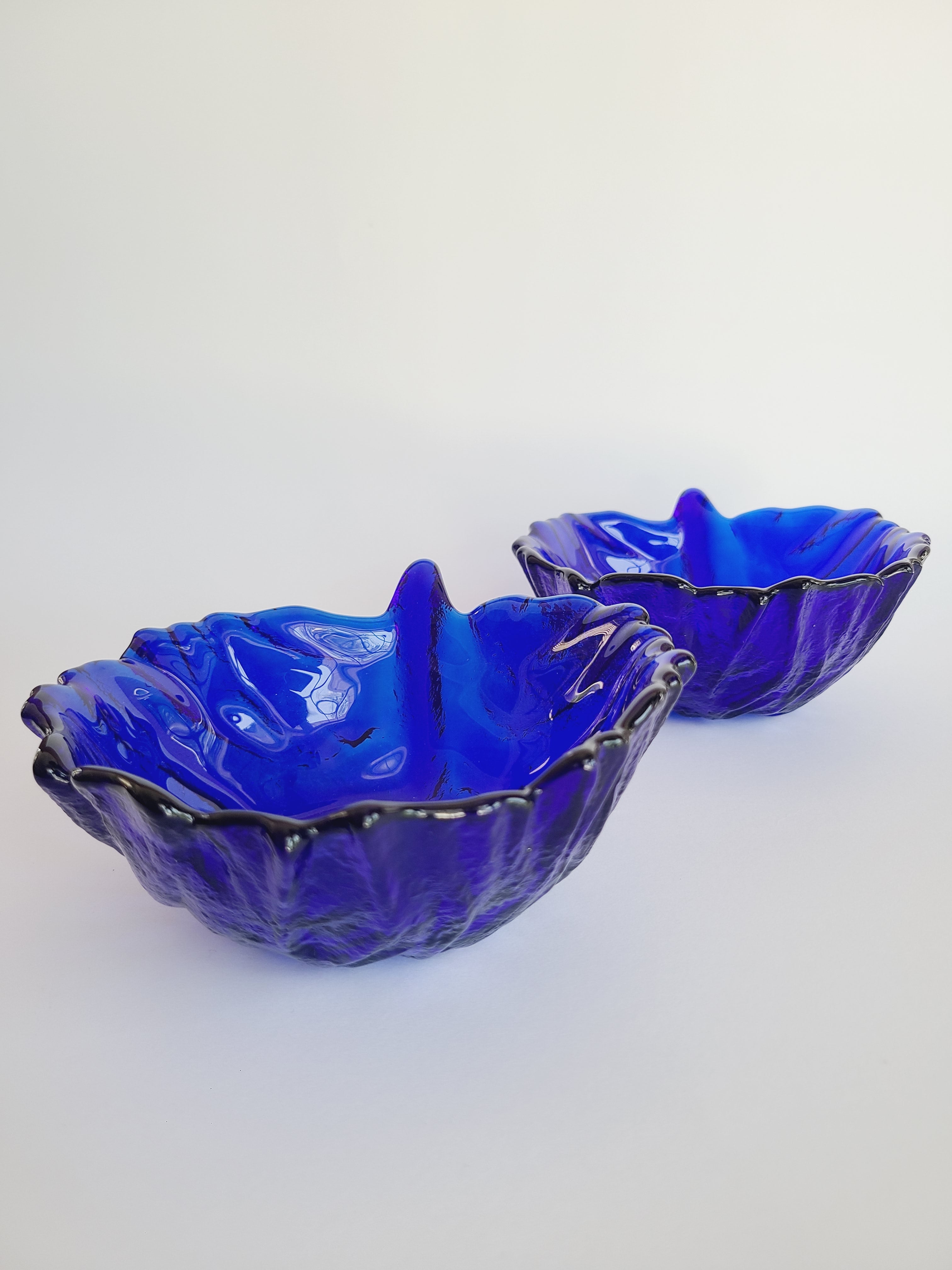 Two vintage Blenko Cabbage Pattern Bowls in Cobalt Blue on white background shown from the side.
