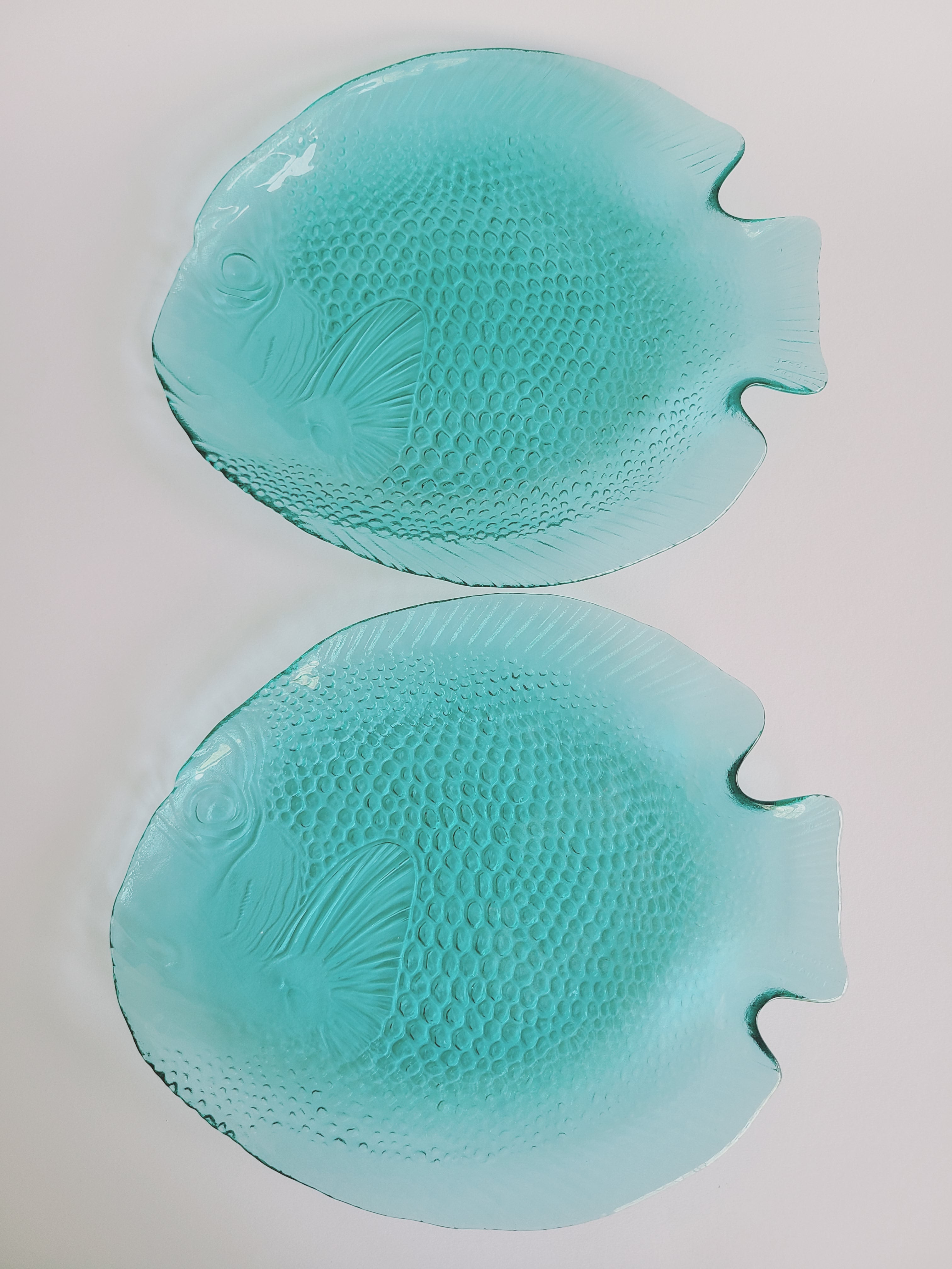 A pair of vintage Arcoroc turquoise glass fish-shaped plates made in France .