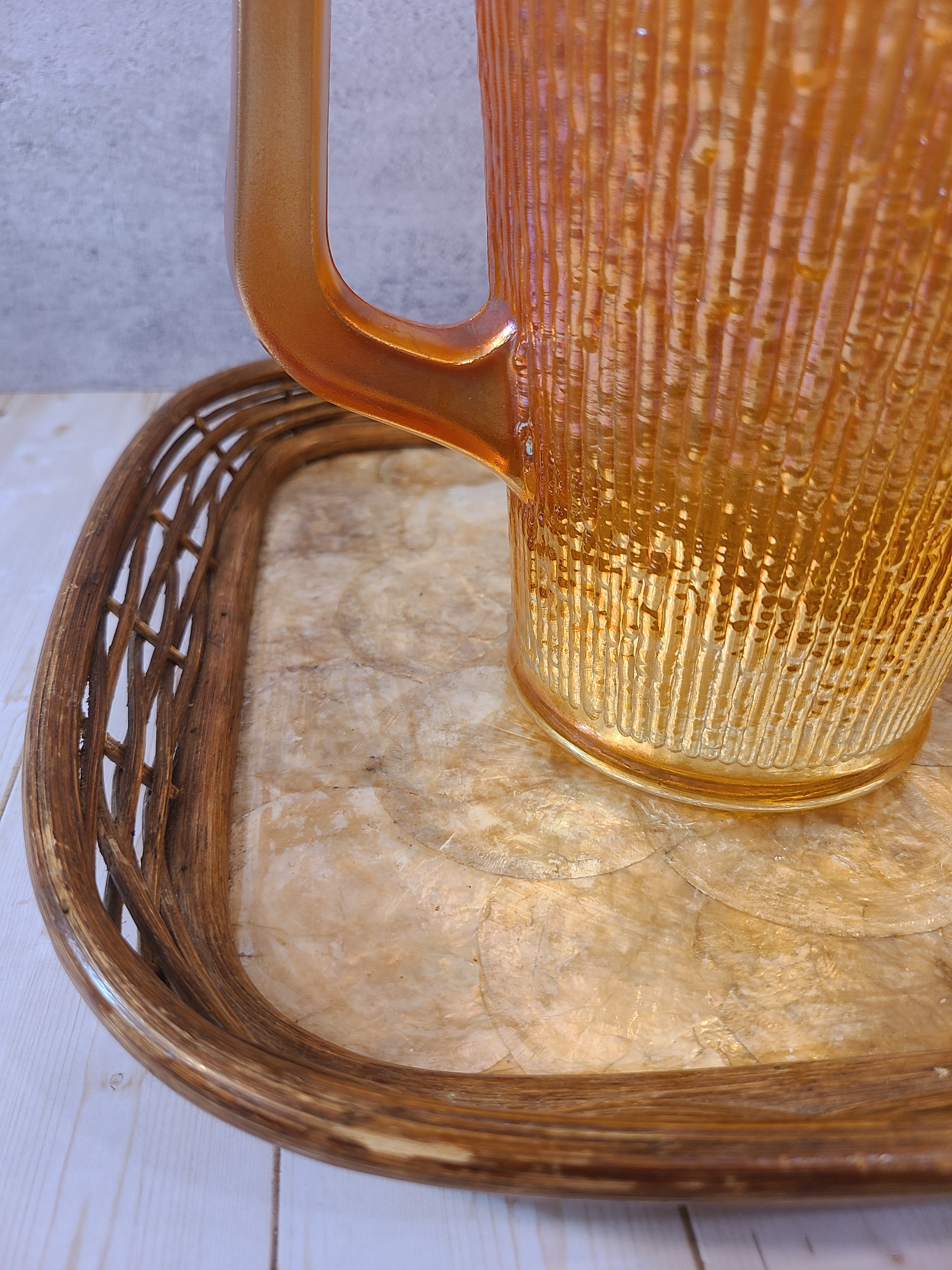 Close up of Vintage Capiz Shell Tray with Rattan Border holding marigold glass pitcher