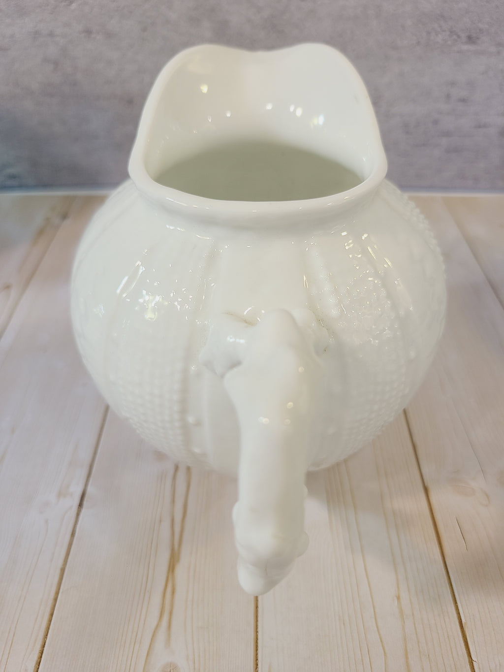 Vintage Paris Royal pitcher or creamer with sea urchin design on a light wood background.