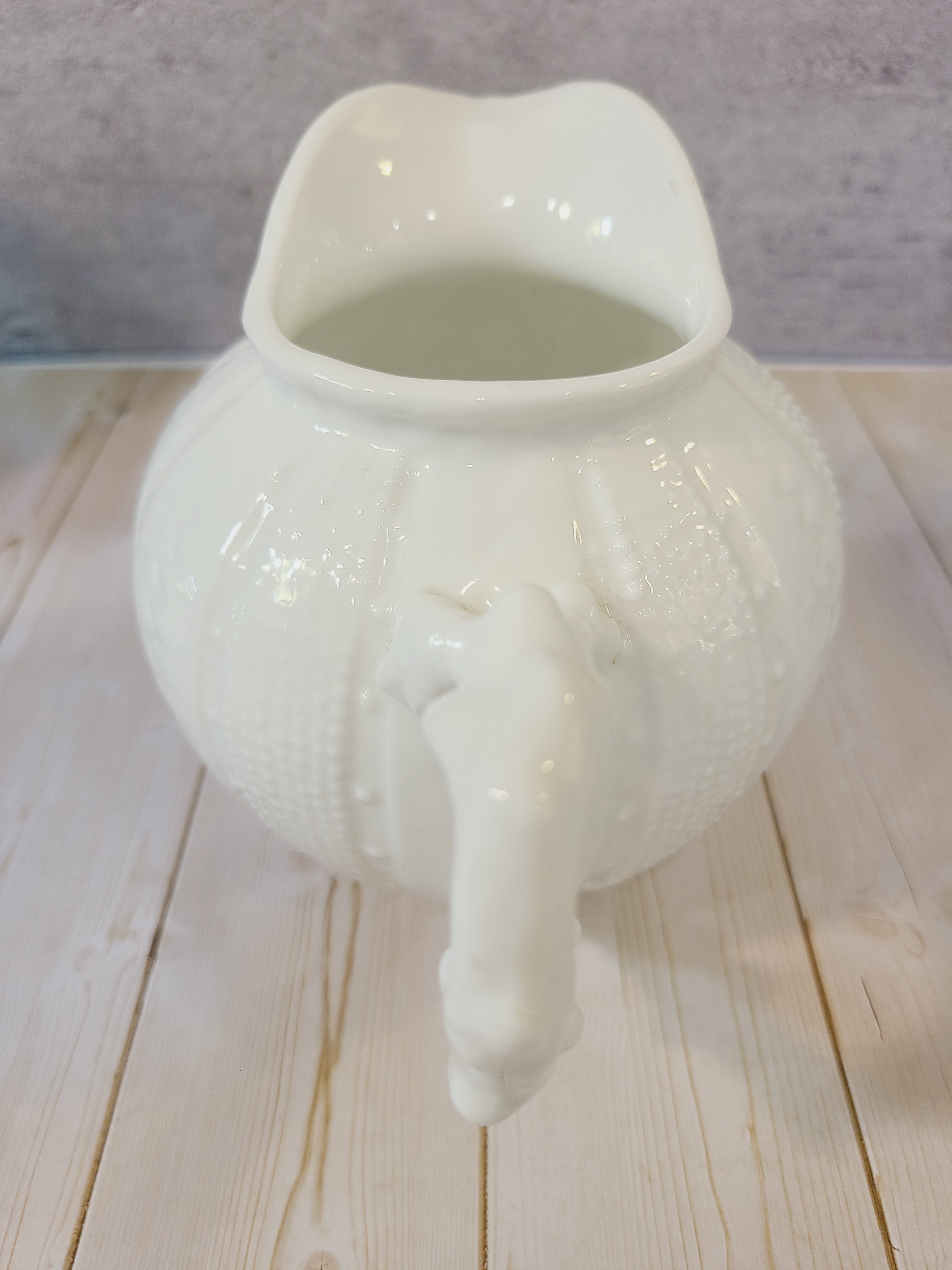 Vintage Paris Royal pitcher or creamer with sea urchin design on a light wood background.