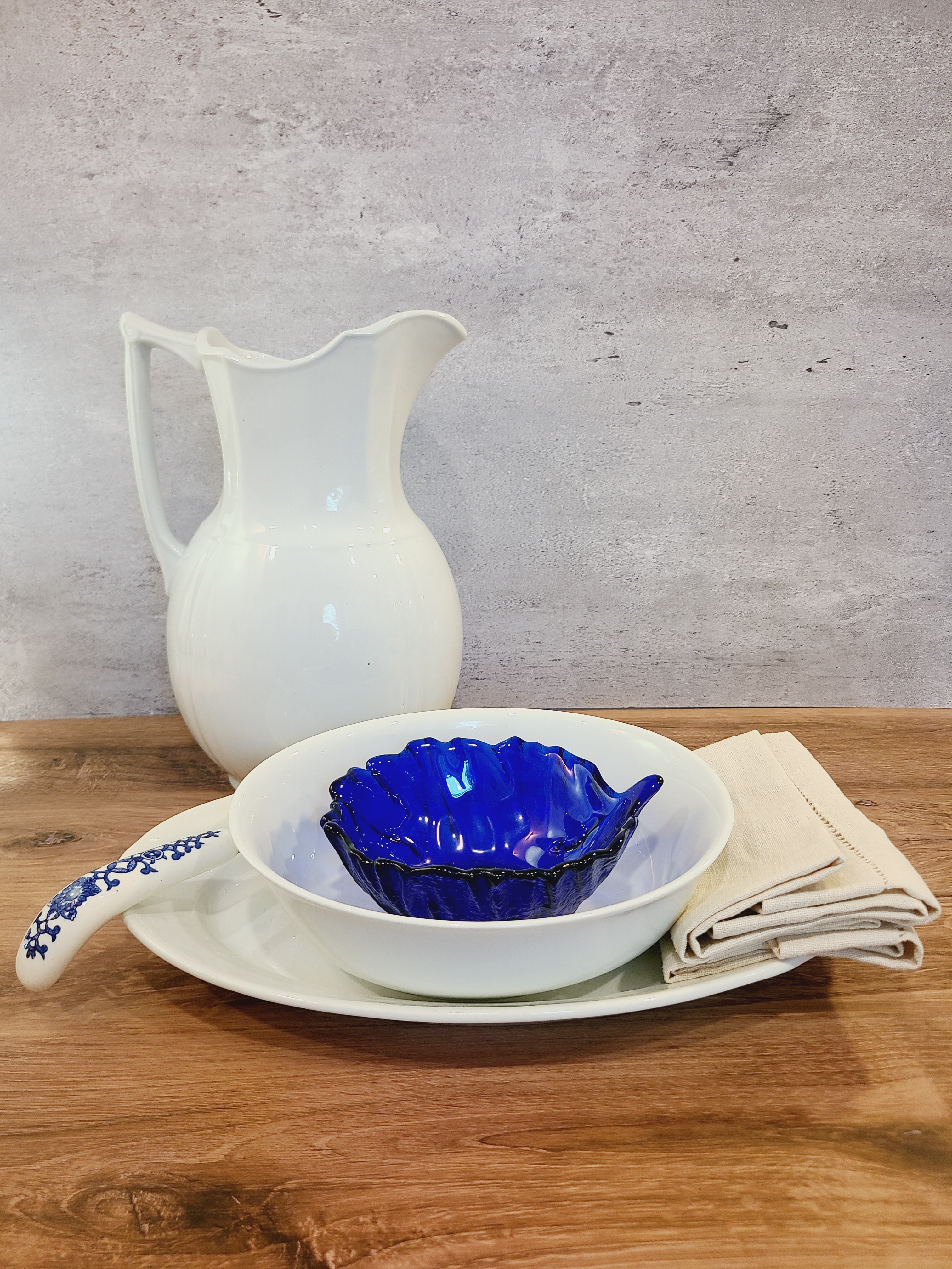 Vntage Blenko Cabbage Pattern Bowls in Cobalt Blue shown with white serve pieces on a wooden table.