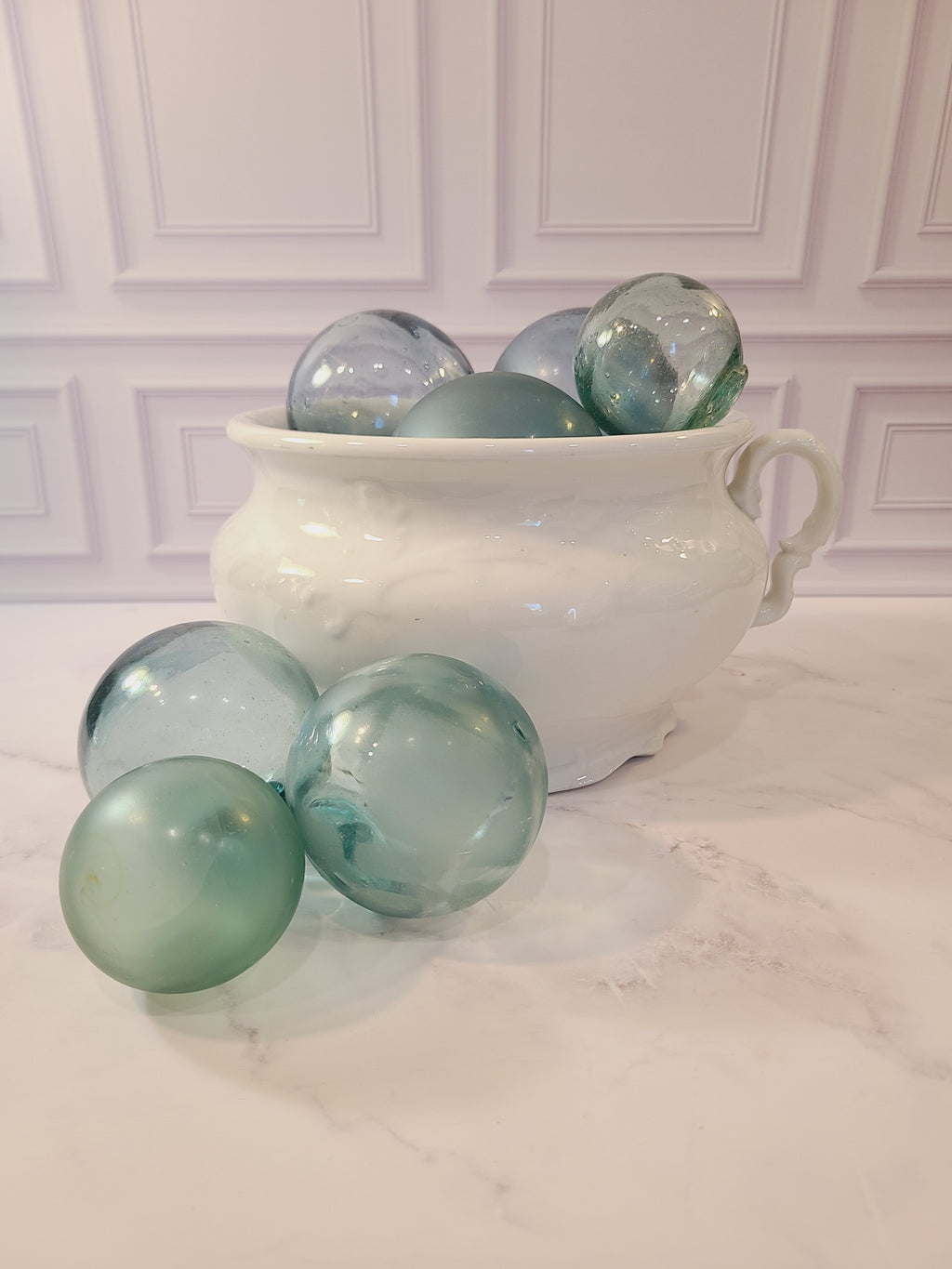 Antique white Mellor, Taylor & Co. English Ironstone Chamber Pot displayed with glass fishing floats.