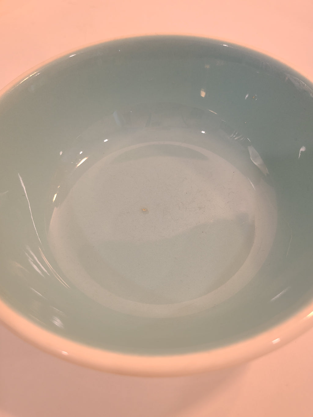 Close up of interior of vintage Chateau Buffet Stoneware Bowl with turquoise interior and white exterior.