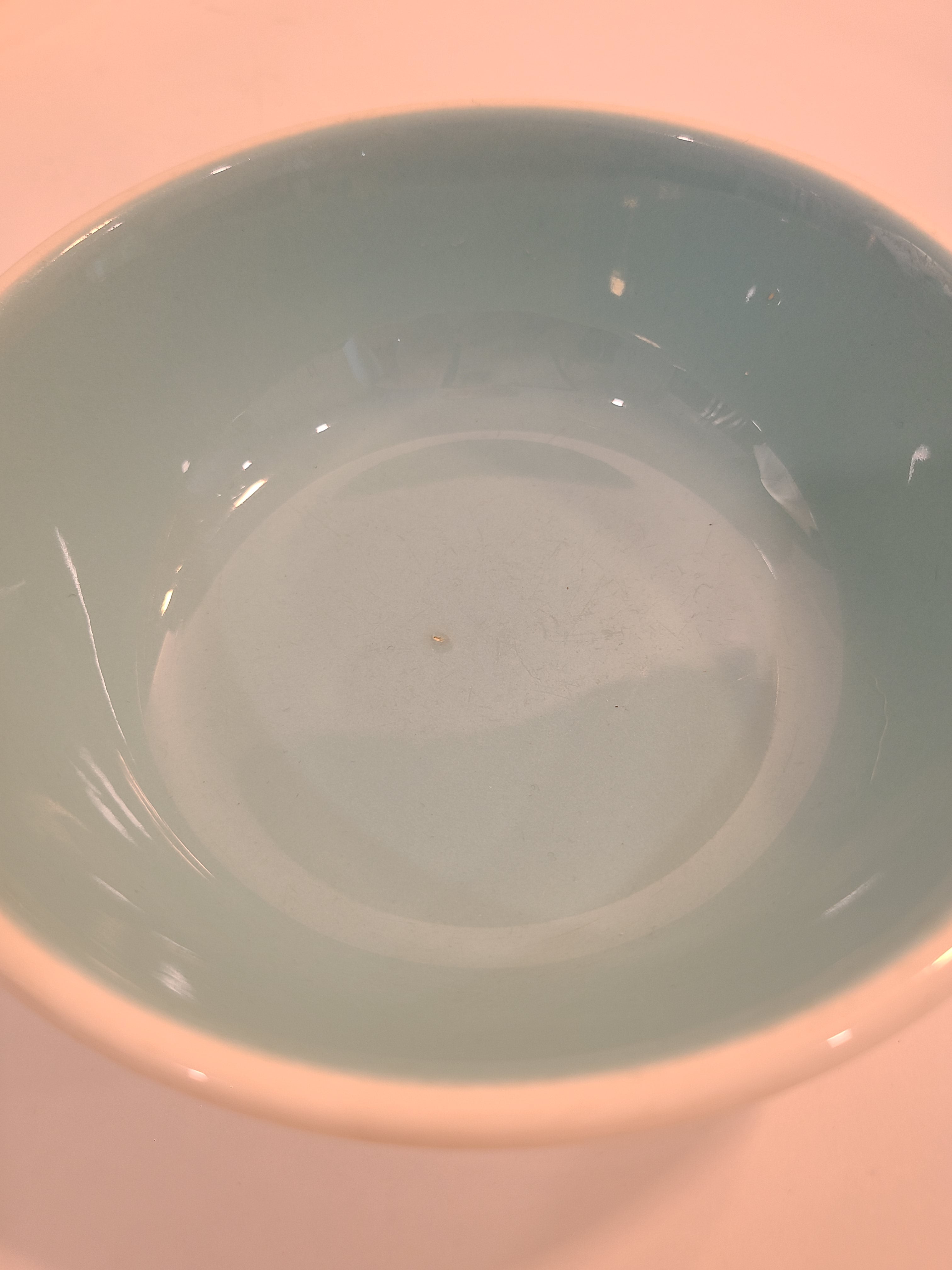 Close up of interior of vintage Chateau Buffet Stoneware Bowl with turquoise interior and white exterior.