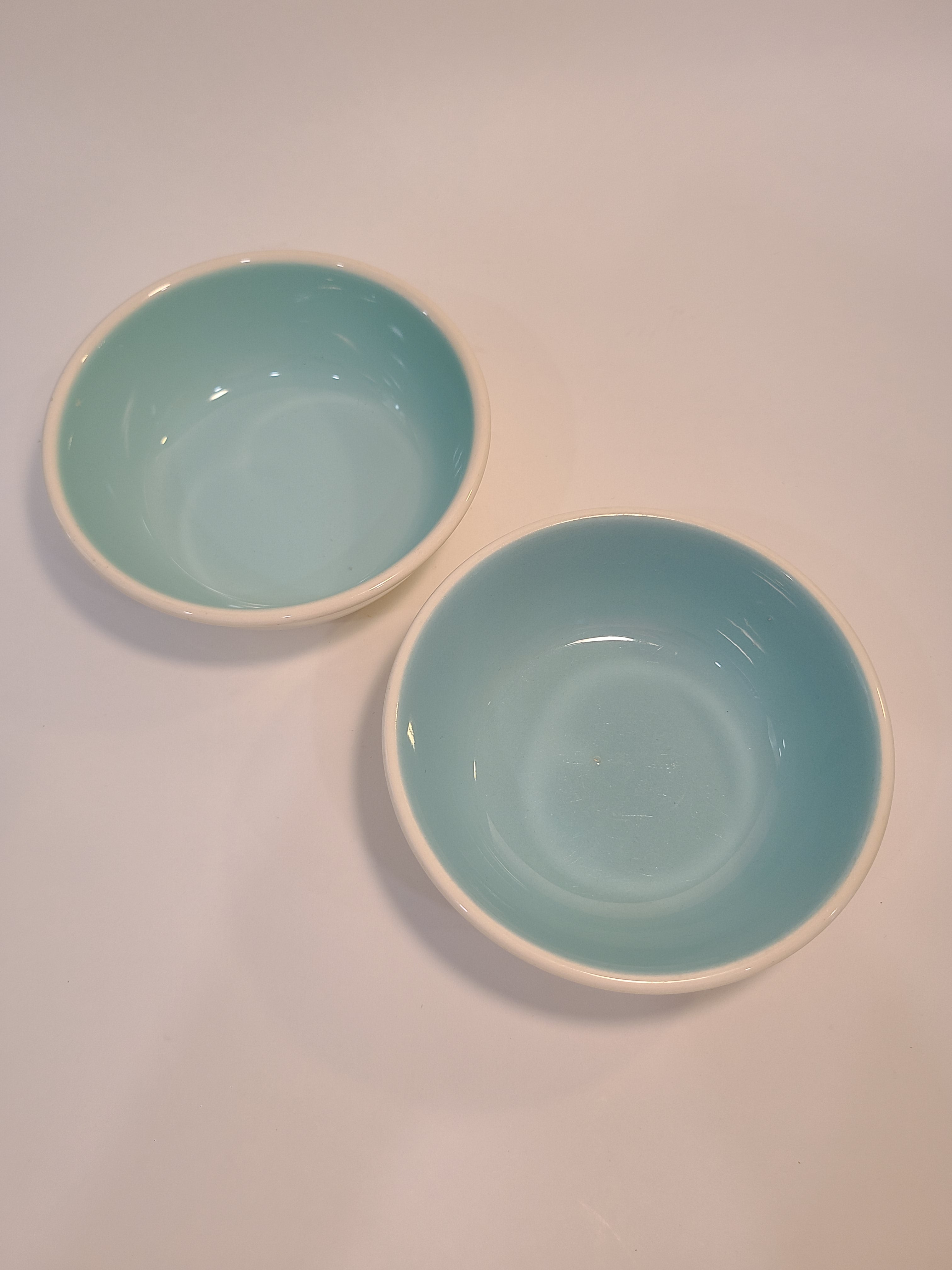 Two vintage Chateau Buffet Stoneware Bowls with turquoise interior and white exterior.