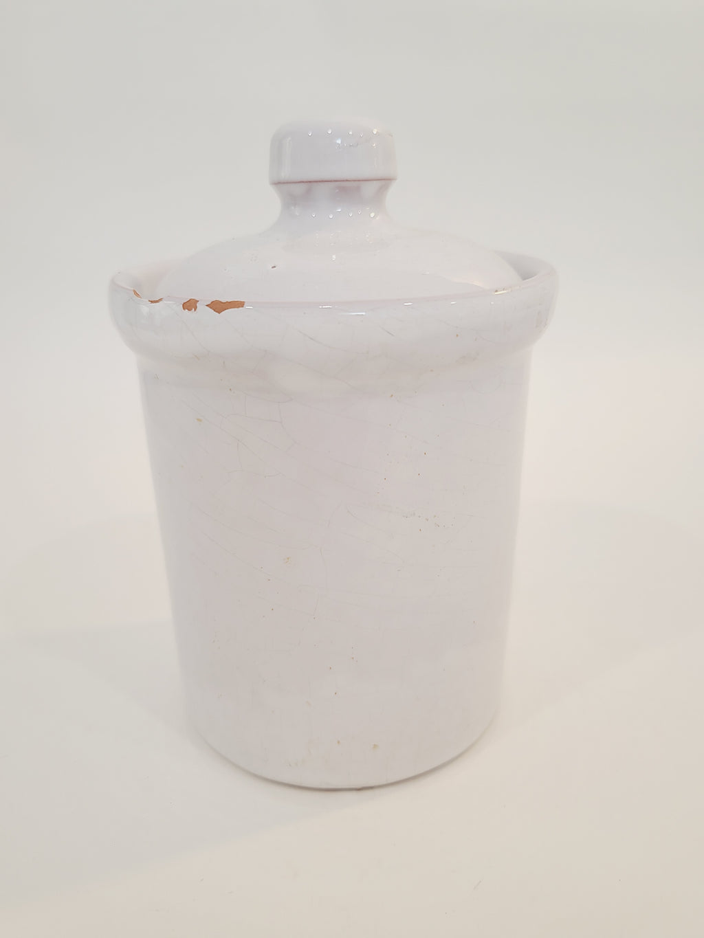 A white ceramic lidded crock with a small knob.