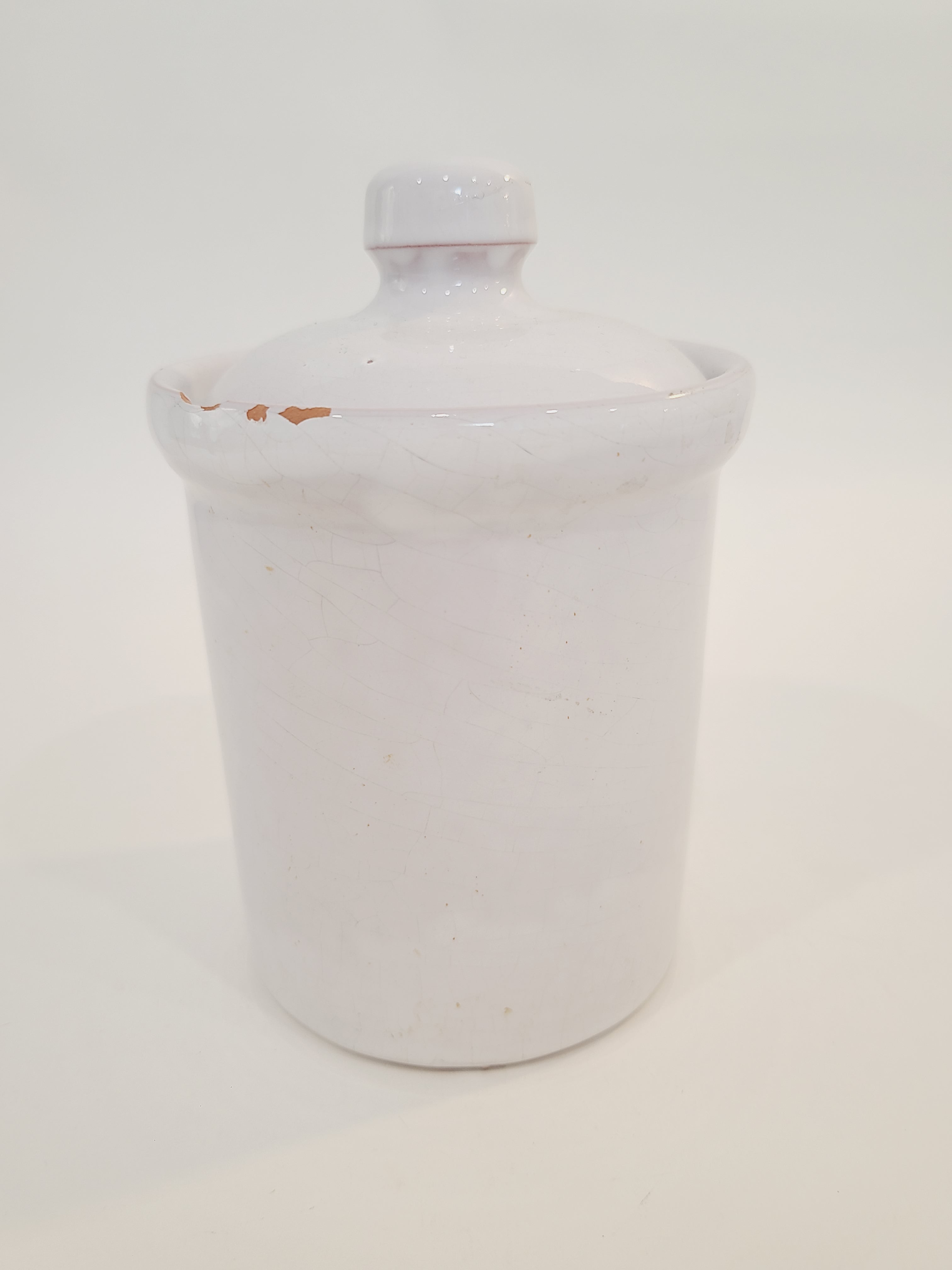 A white ceramic lidded crock with a small knob.