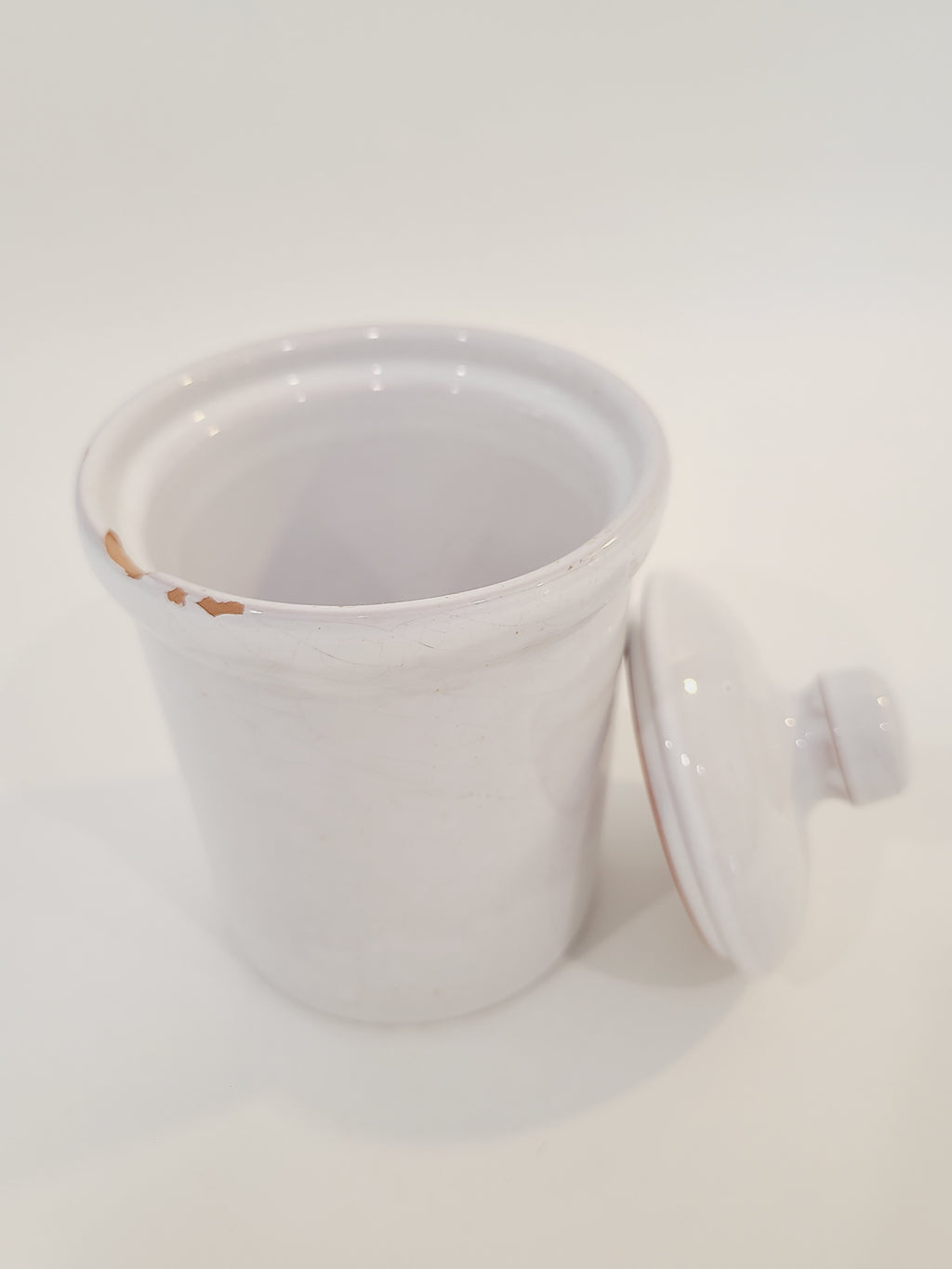 A white ceramic lidded crock with a glossy finish, photographed against a plain white background.