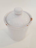 A white glazed ceramic lidded crock with a small knob on top, photographed on a plain white background.
