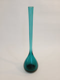 A translucent vintage teal glass vase with a long cylindrical neck and a bulbous rounded base made in Sweden, shown against a plain off-white background.
